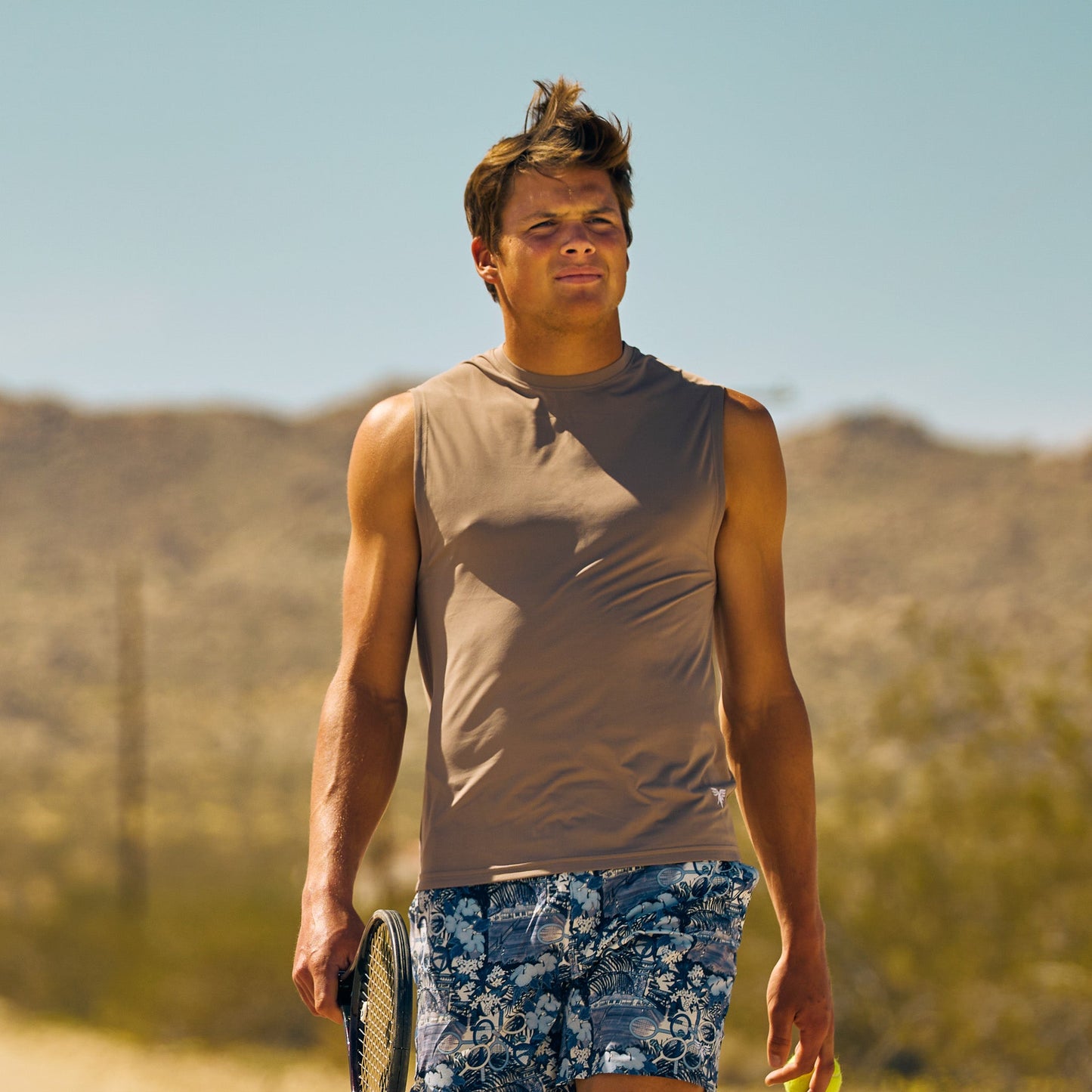 Model wearing Sigrún men's tank top and carrying a tennis racquet.