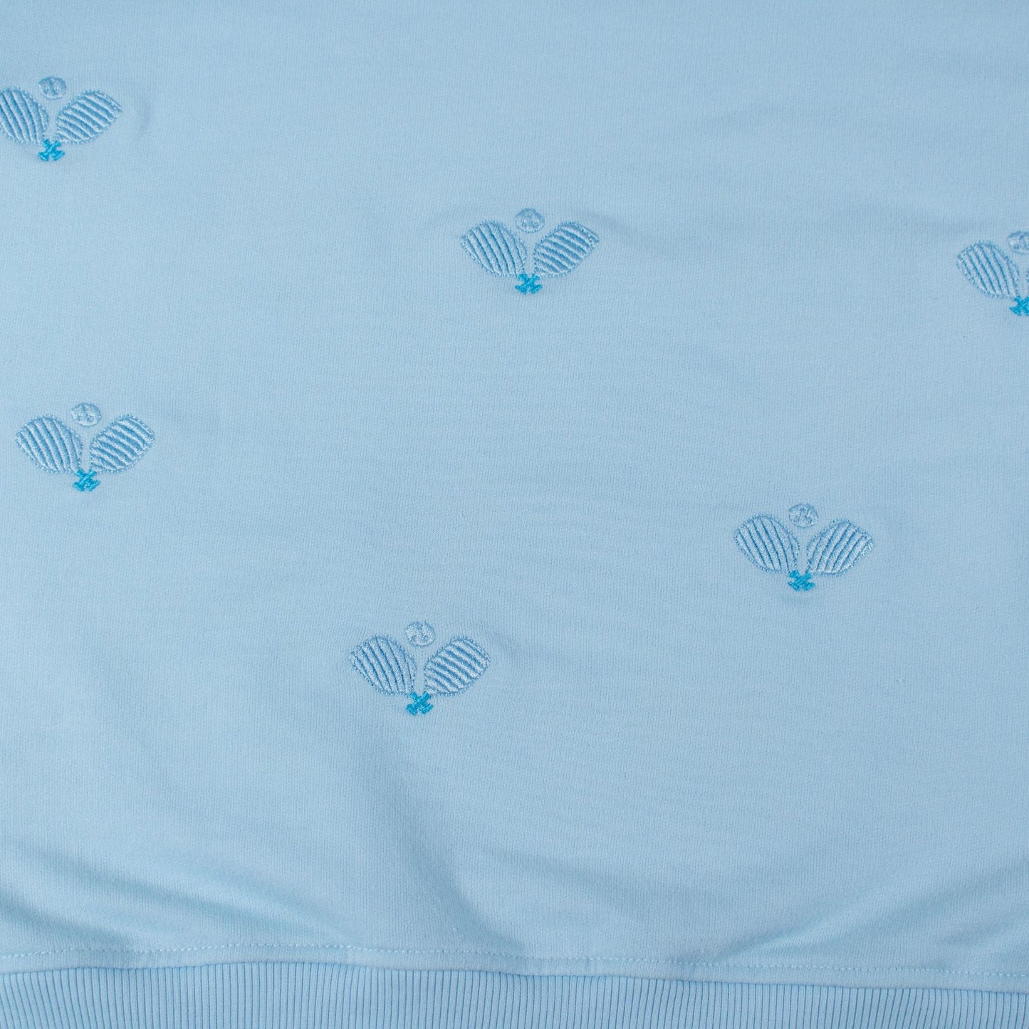 Light blue fabric with embroidered patterns on a light blue background