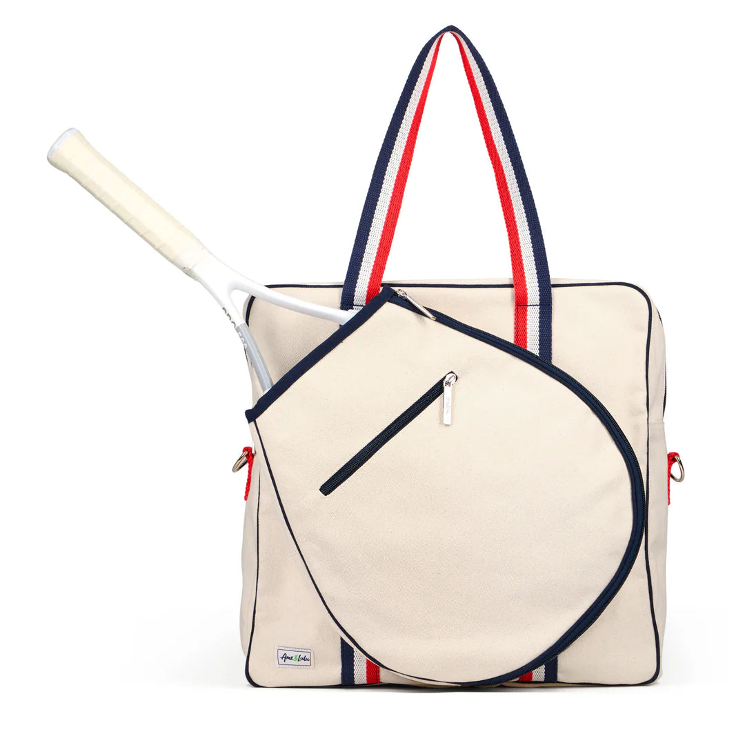 Beige tote bag with red and blue straps and a tennis racket inside on a white background