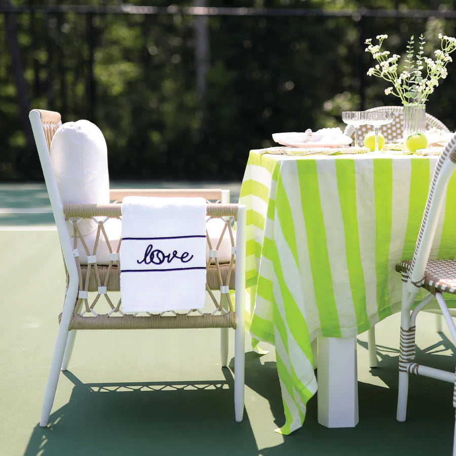 White tennis towel with "love" written in blue hanging on a chair at a country club.