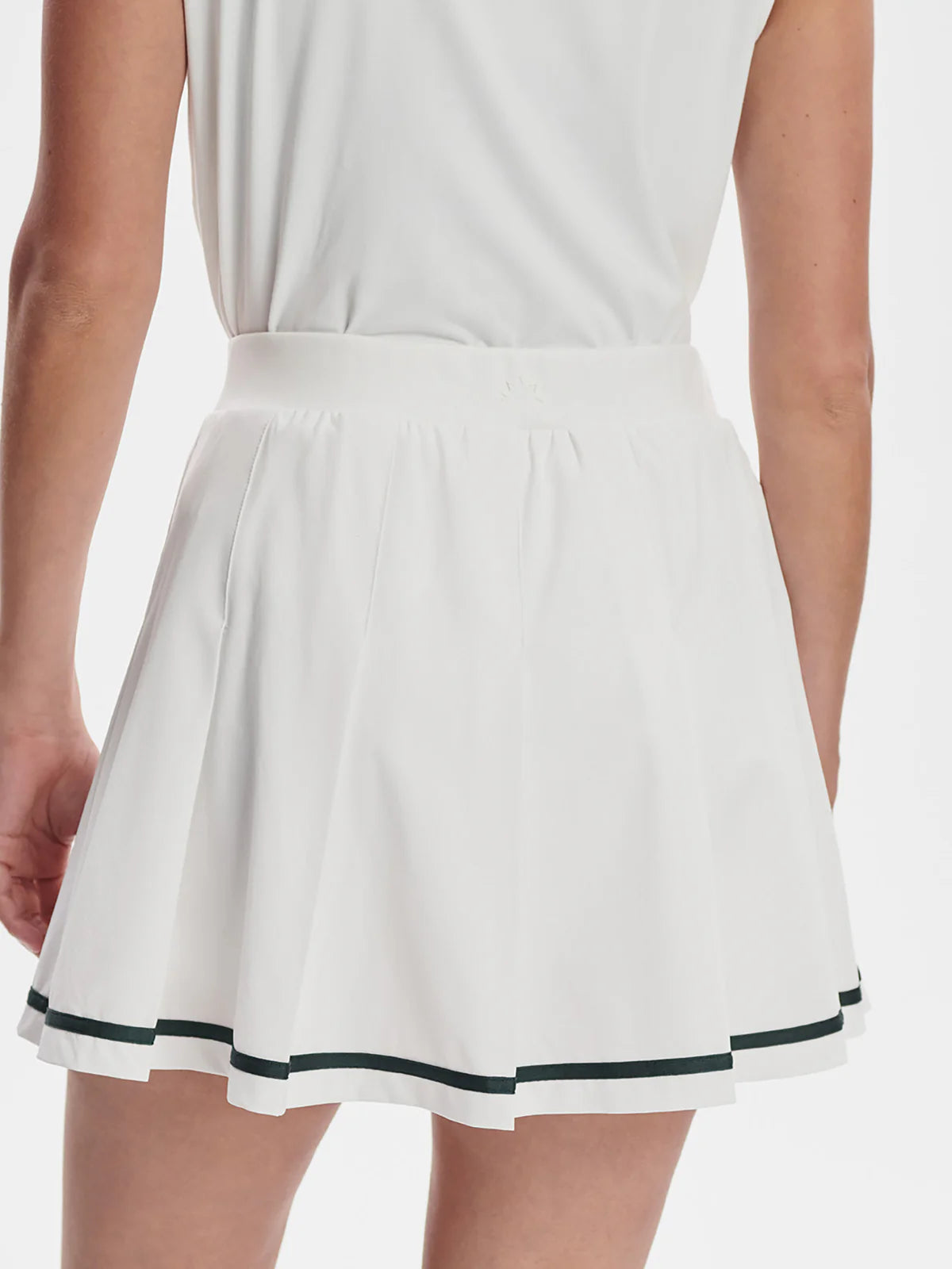 Varley white skirt with navy blue trim worn by a person on a white background on tennisdujour.com