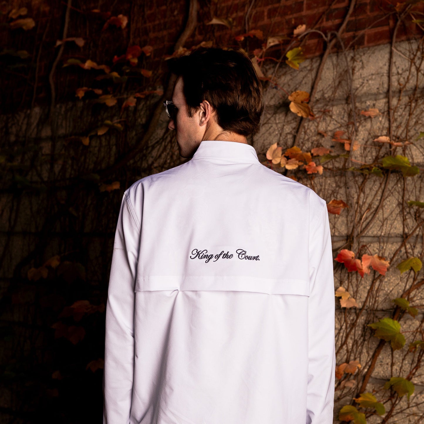 Model wearing Sigrún match jacket in white with "king of the court" on the back.