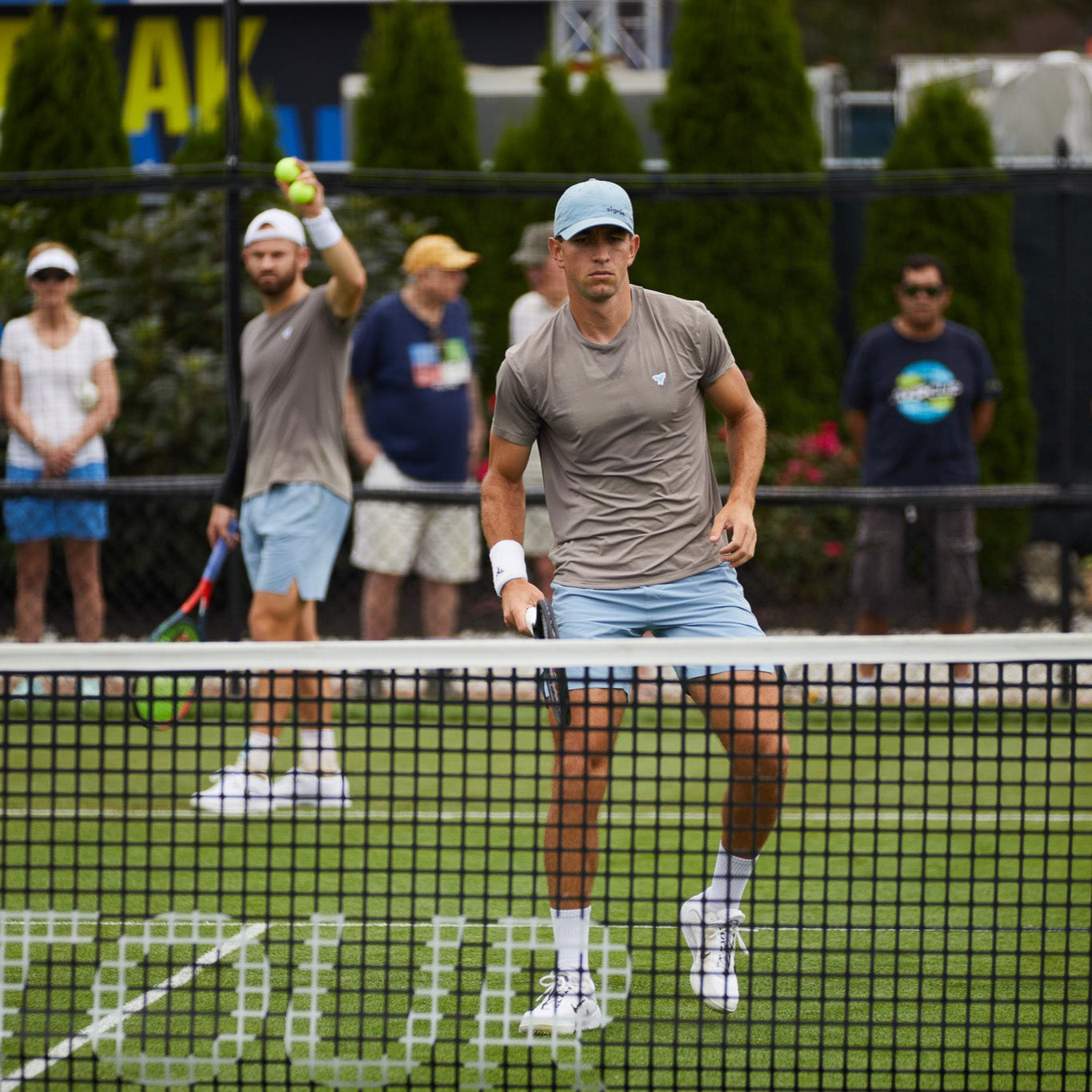 Model playing tennis wearing Sigrún gray match tee.