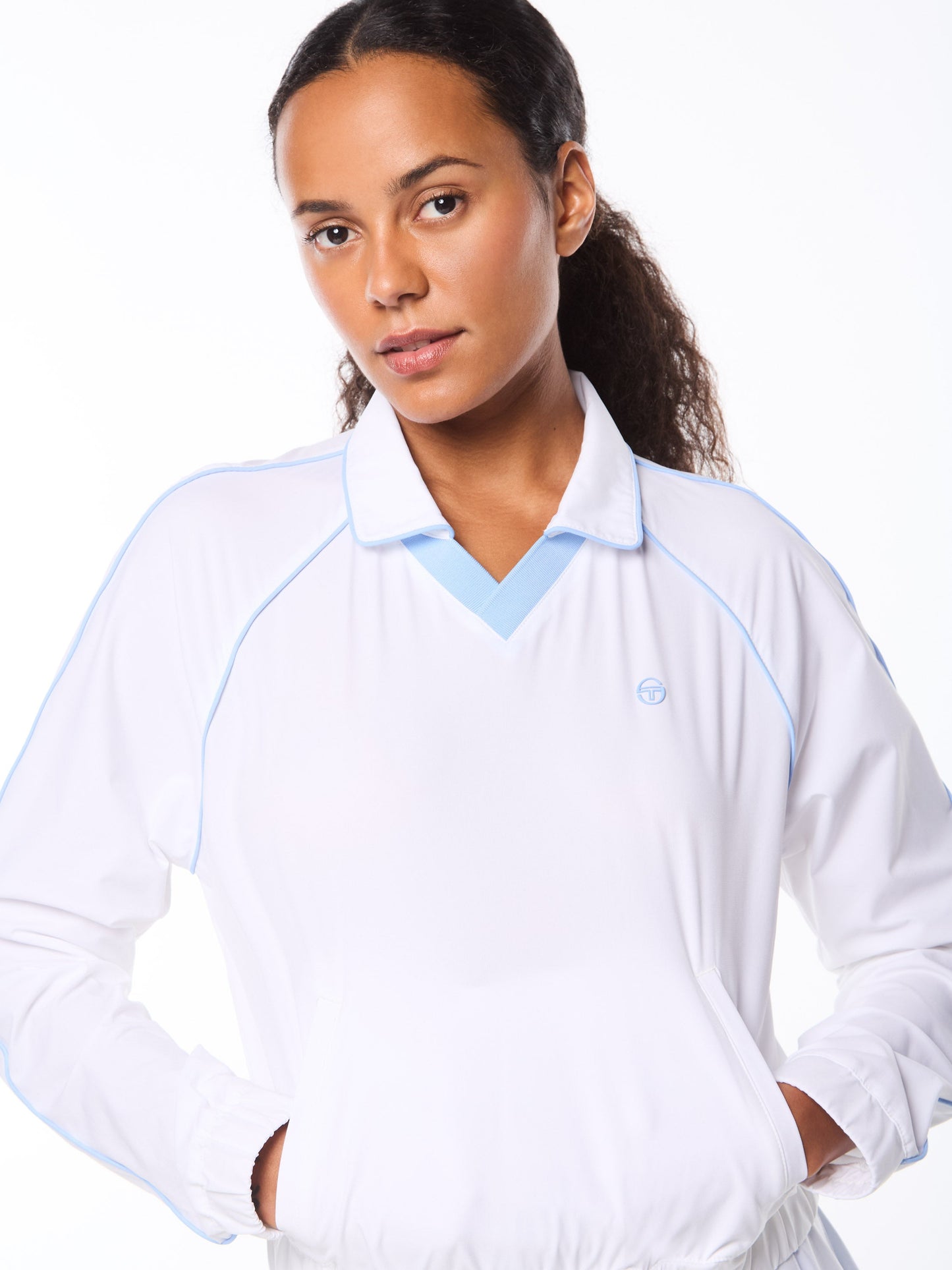 Woman wearing a white long-sleeve shirt with blue accents on a white background
