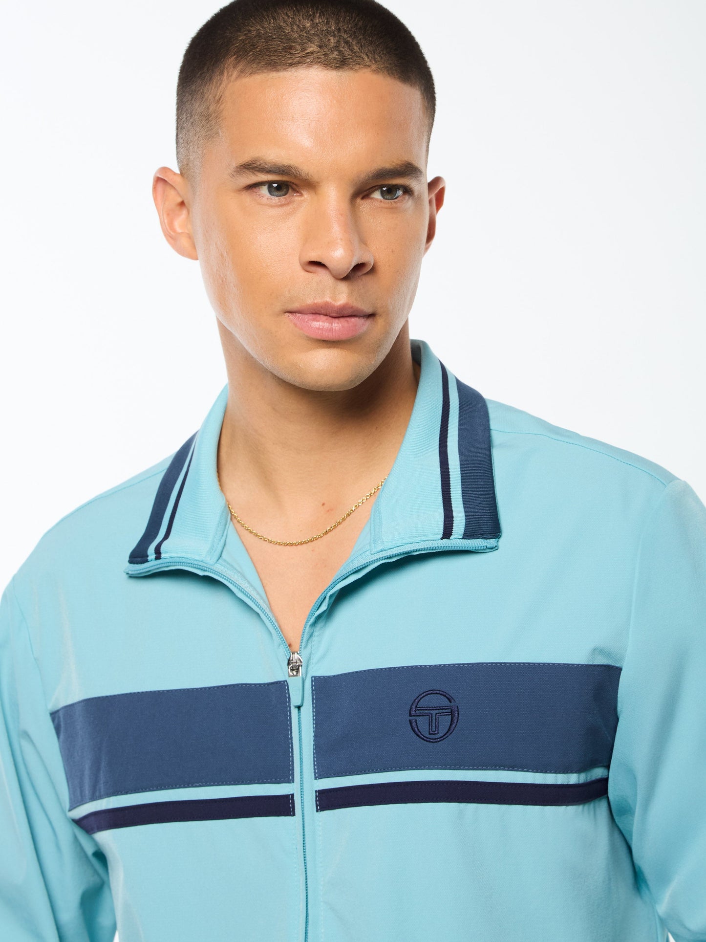Man wearing a light blue jacket with navy accents on a white background