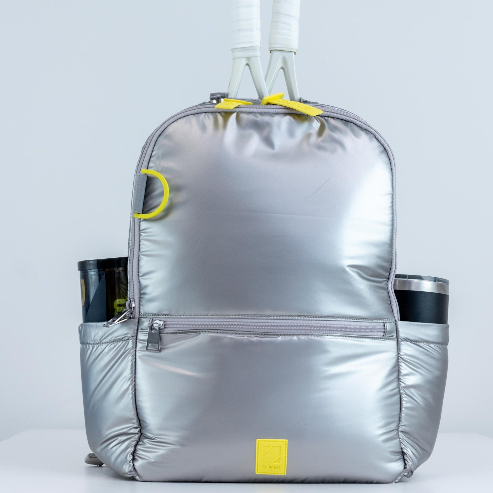Silver backpack with yellow accents on a light gray background