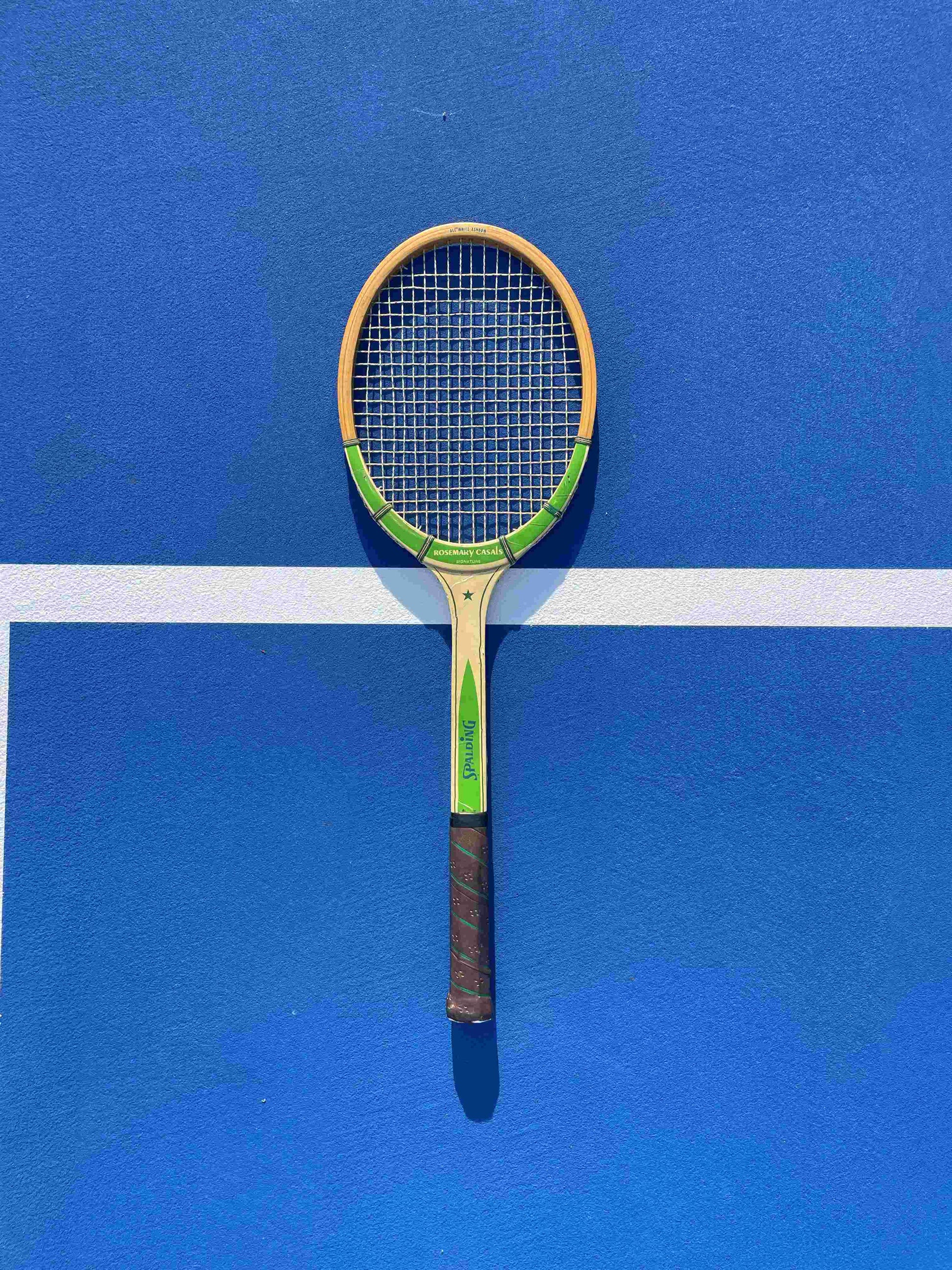 Tennis racket on a blue court with a white line