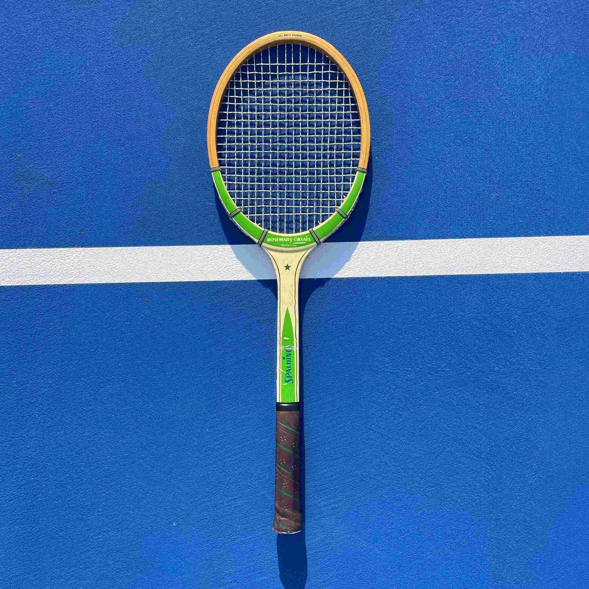 Tennis racket on a blue court with a white line