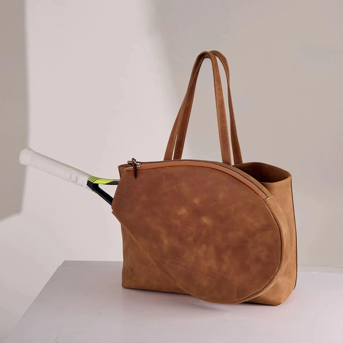 Genuine leather bag with removable tennis racket cover.