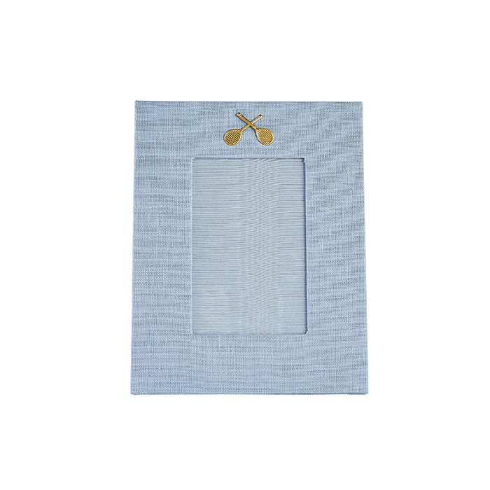Light blue linen picture with gold medallion of crossed tennis racquets on Tennis DuJour.