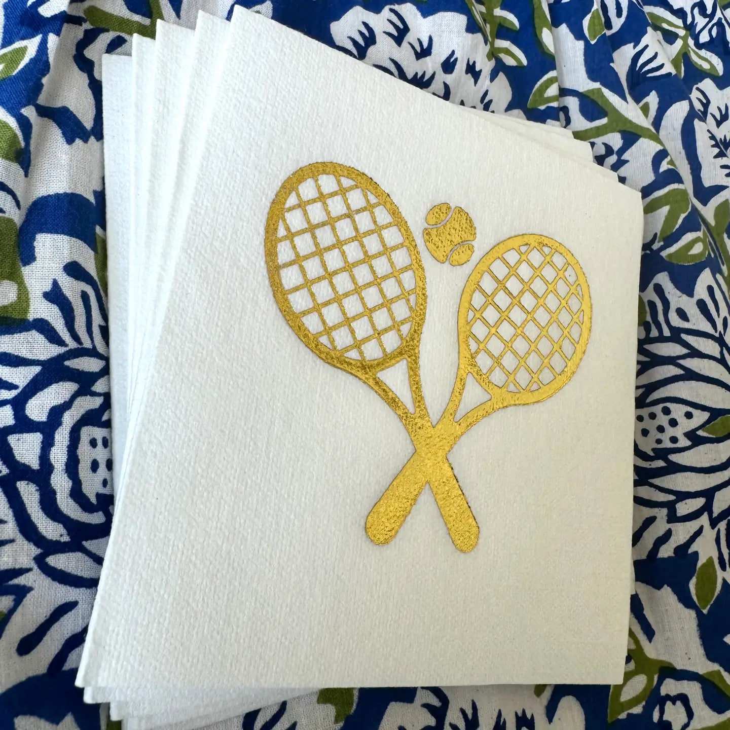 Cream linen cocktail napkins with gold tennis ball and racquets on Tennis DuJour.