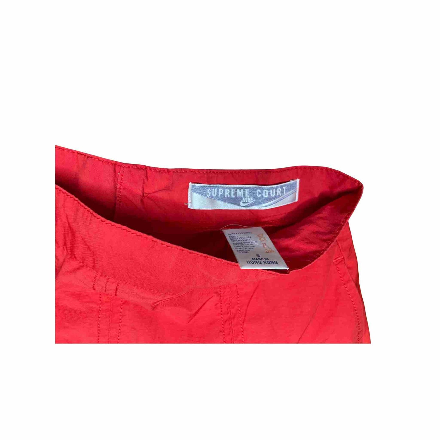 Close-up of a red tennis with Supreme Court label on a white background