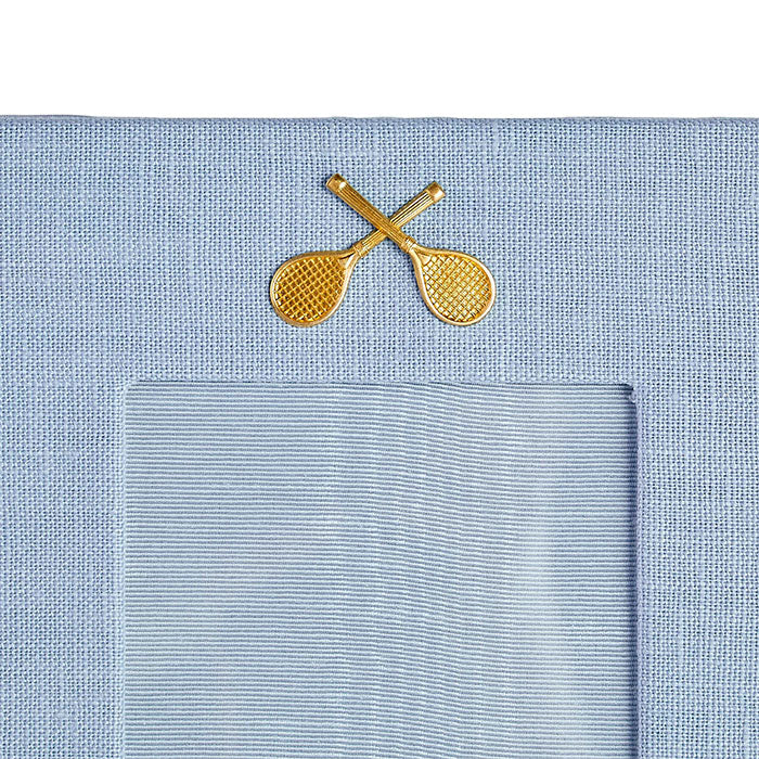 Light blue linen picture with gold medallion of crossed tennis racquets on Tennis DuJour.