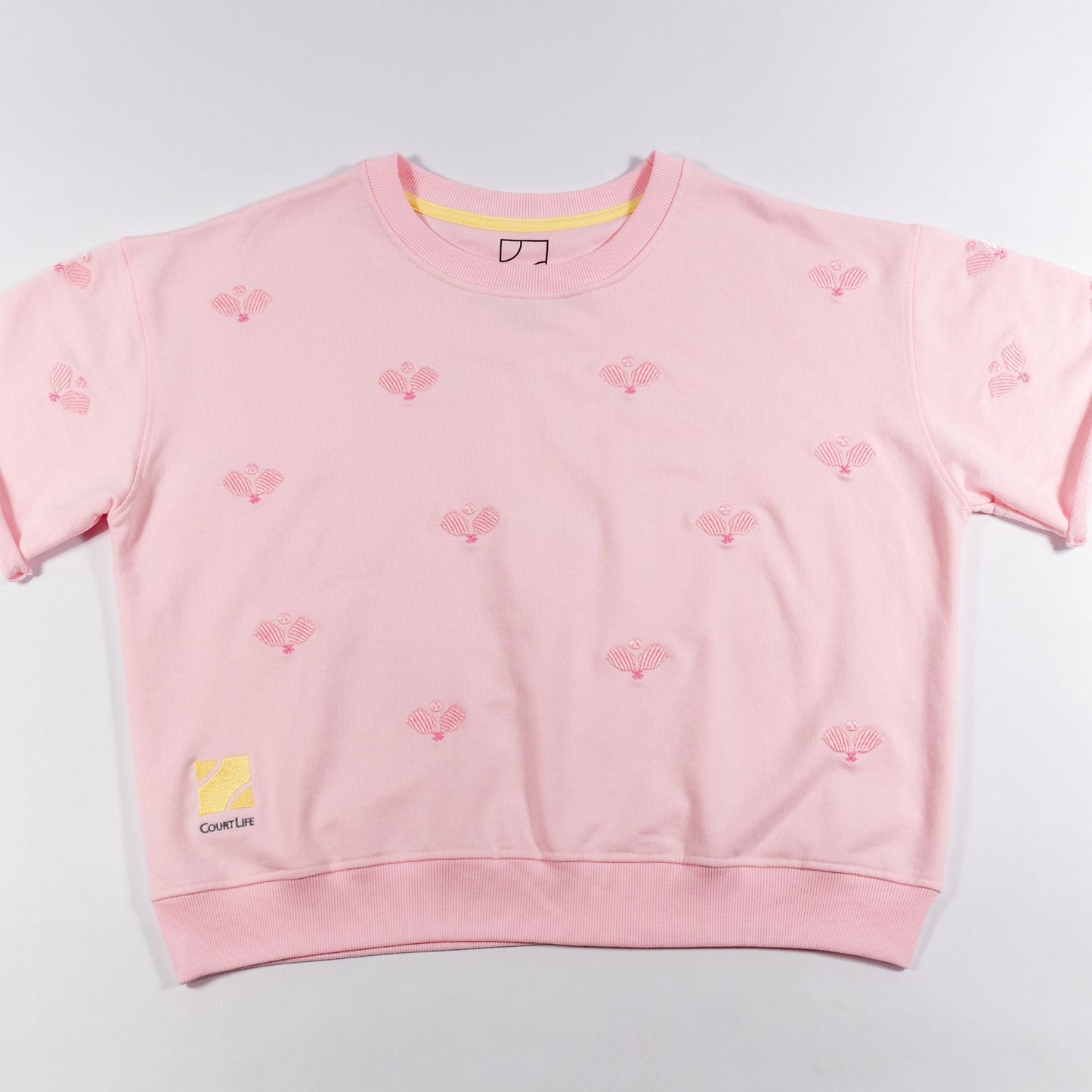 Pink sweatshirt with small designs on a light gray background
