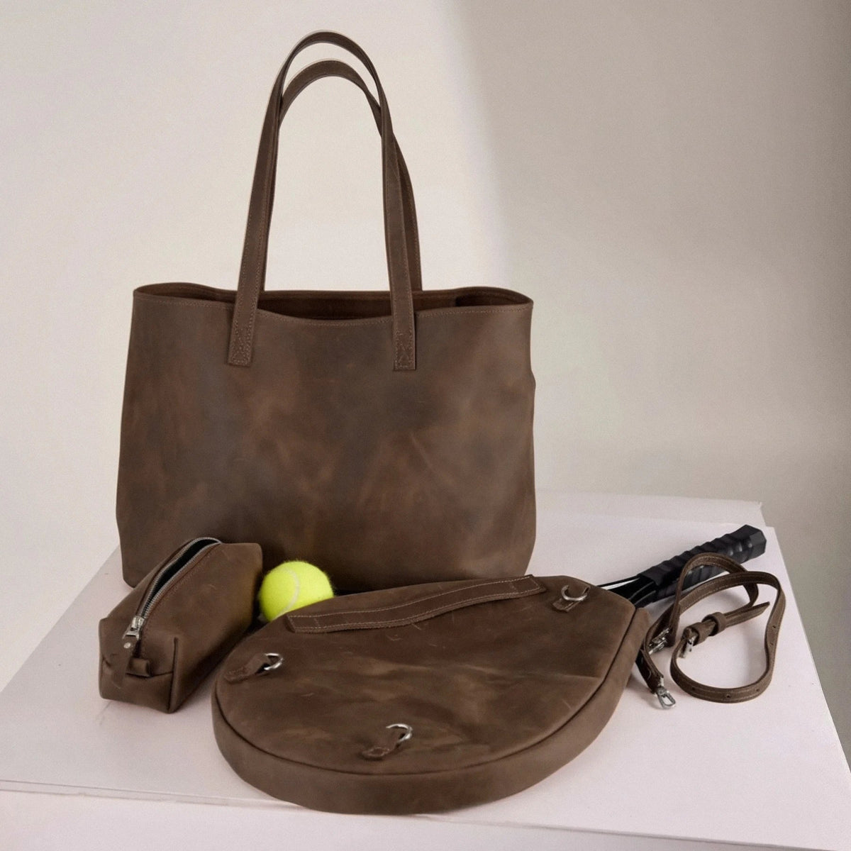 Genuine leather bag with removable tennis racket cover.