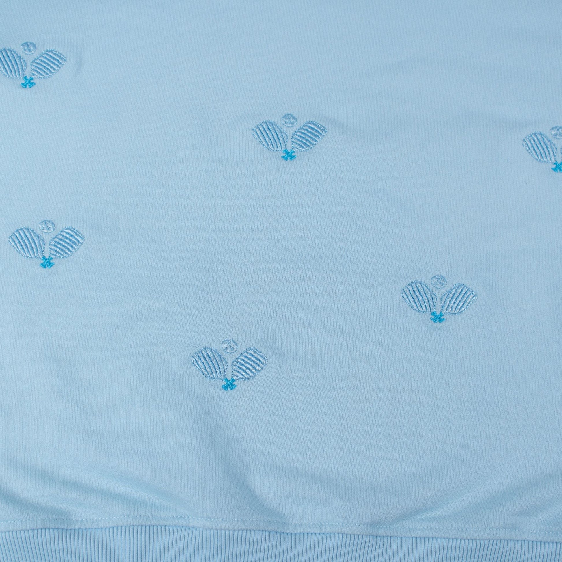 Light blue fabric with embroidered patterns on a light blue background