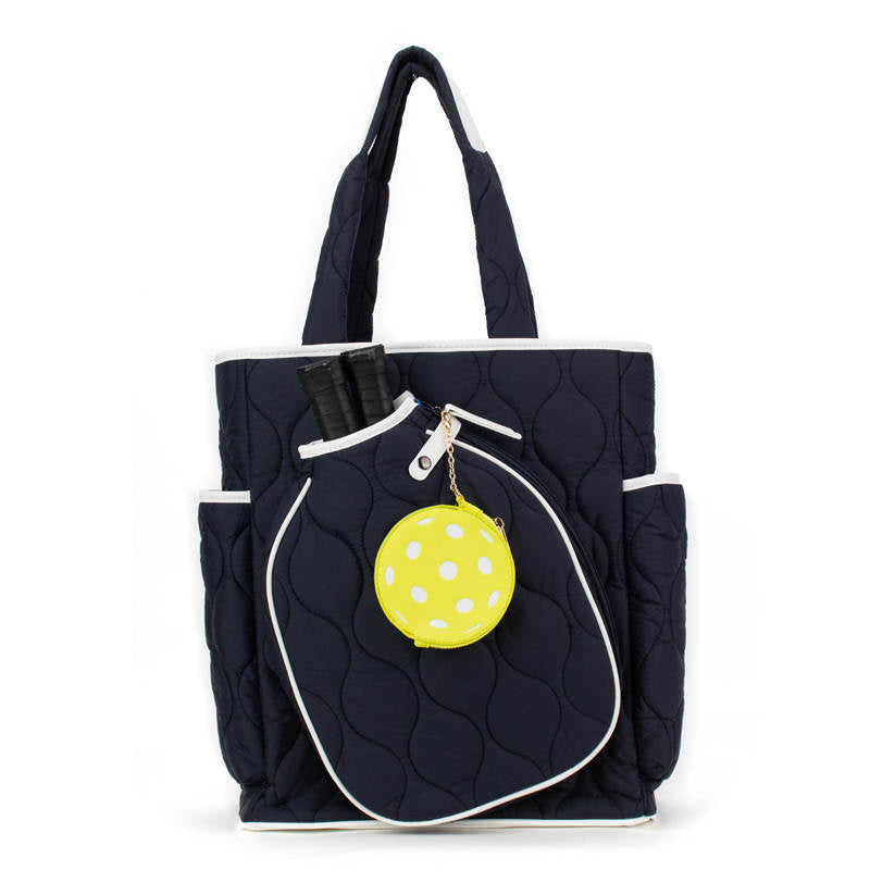 Navy blue tote bag with a yellow polka dot charm on a white background
