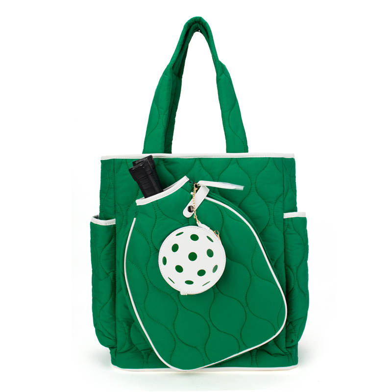 Green quilted pickleball bag with a white polka dot charm on a white background