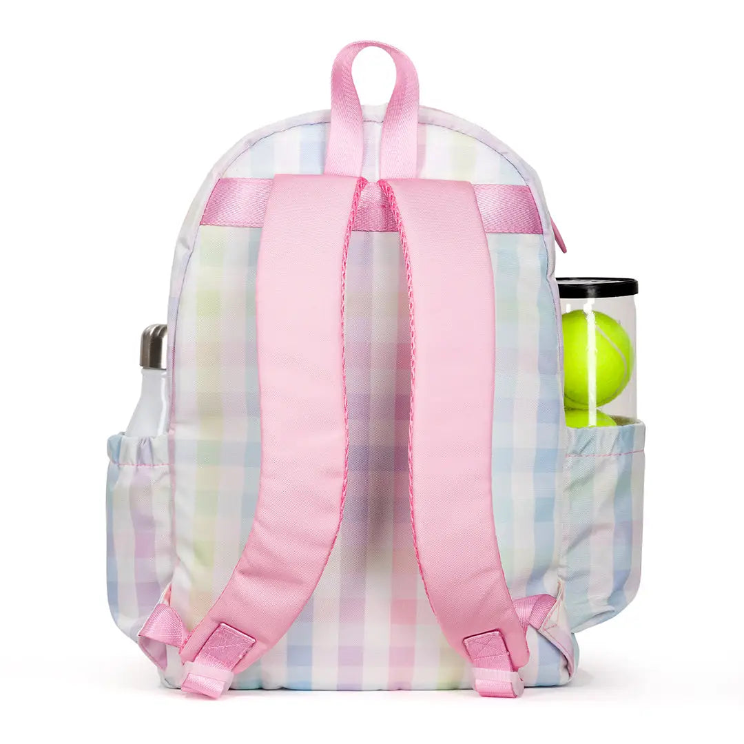 Backpack with pink straps and a pastel plaid pattern, containing tennis balls.