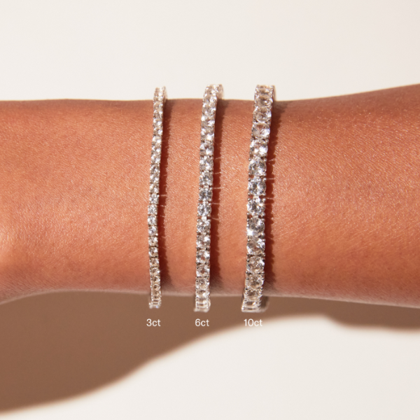 Three diamond bracelets of different sizes on a wrist with visible weight measurements.