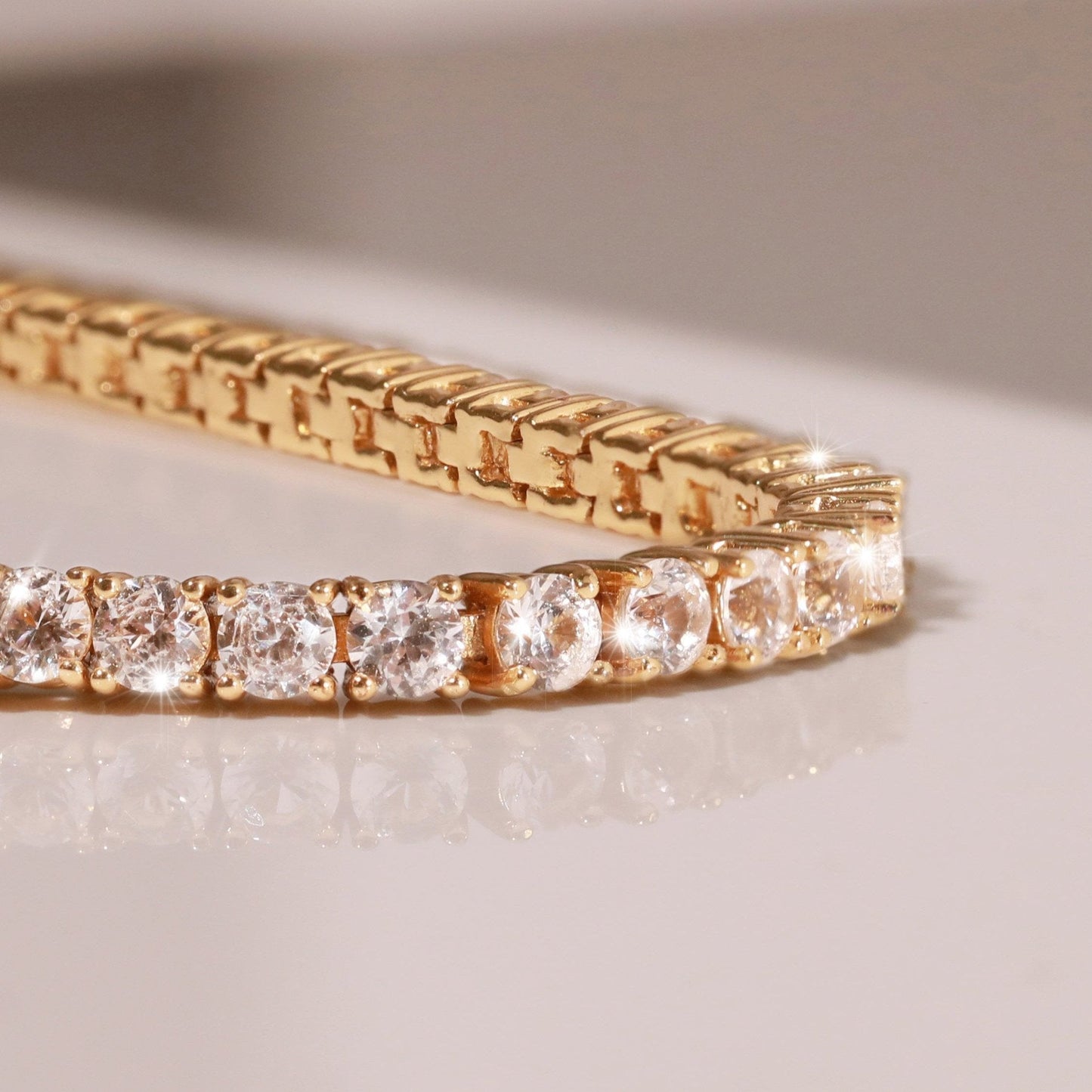 Gold bracelet with diamond accents on a light background