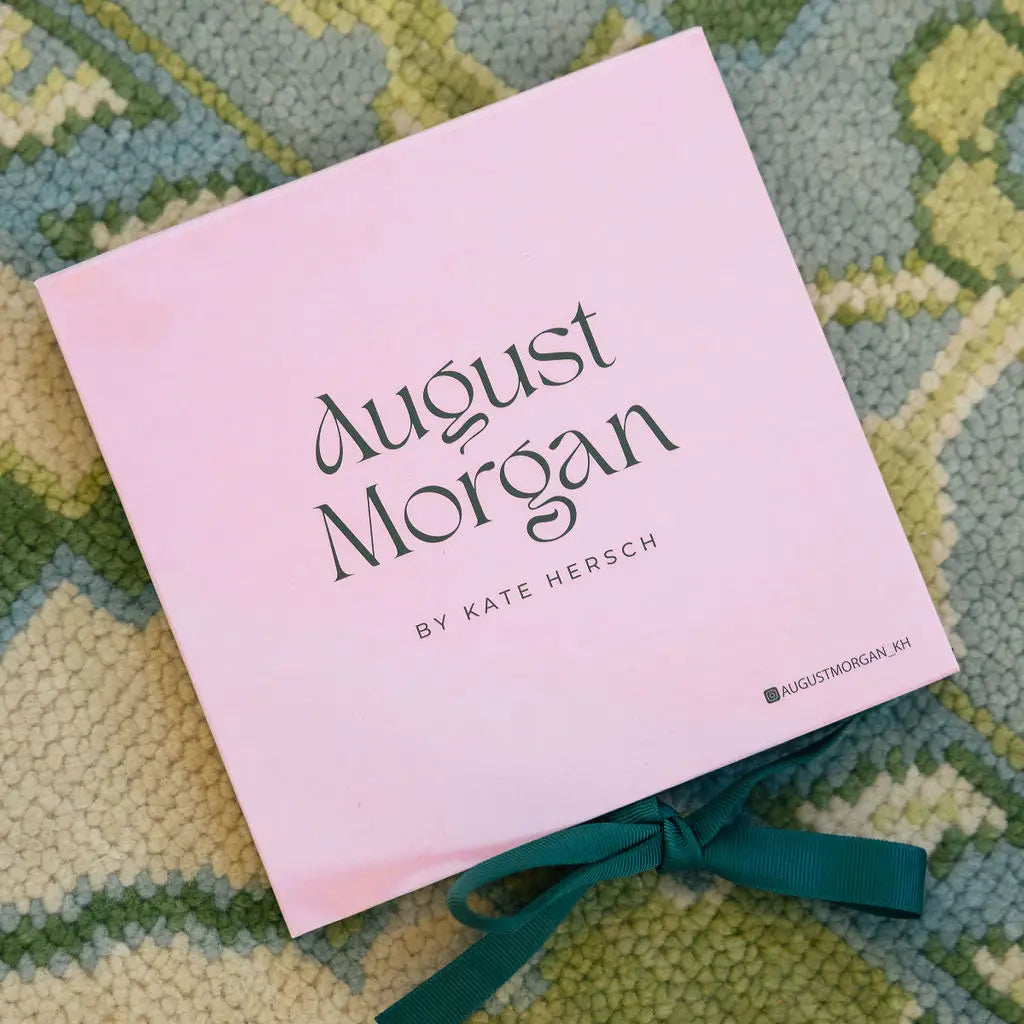 Pink book titled 'August Morgan' by Kate Hersch on a textured surface
