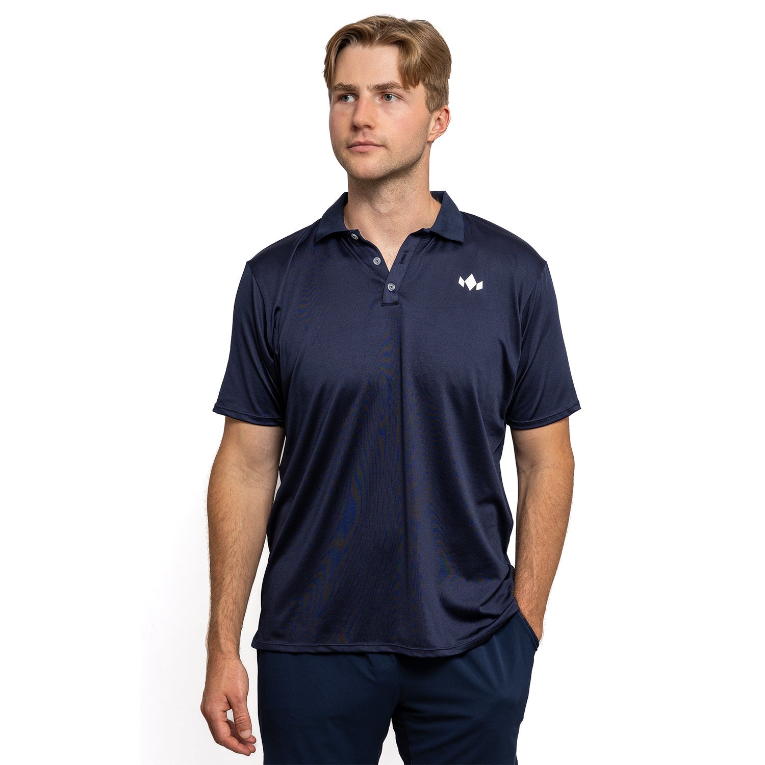 Man wearing a navy blue polo shirt with a logo on a white background