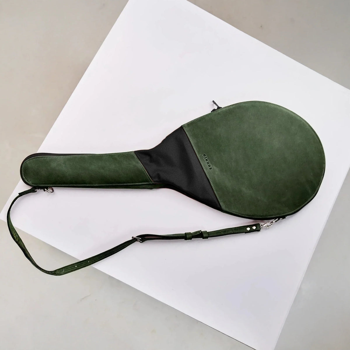 Green and black leather tennis racquet cover.