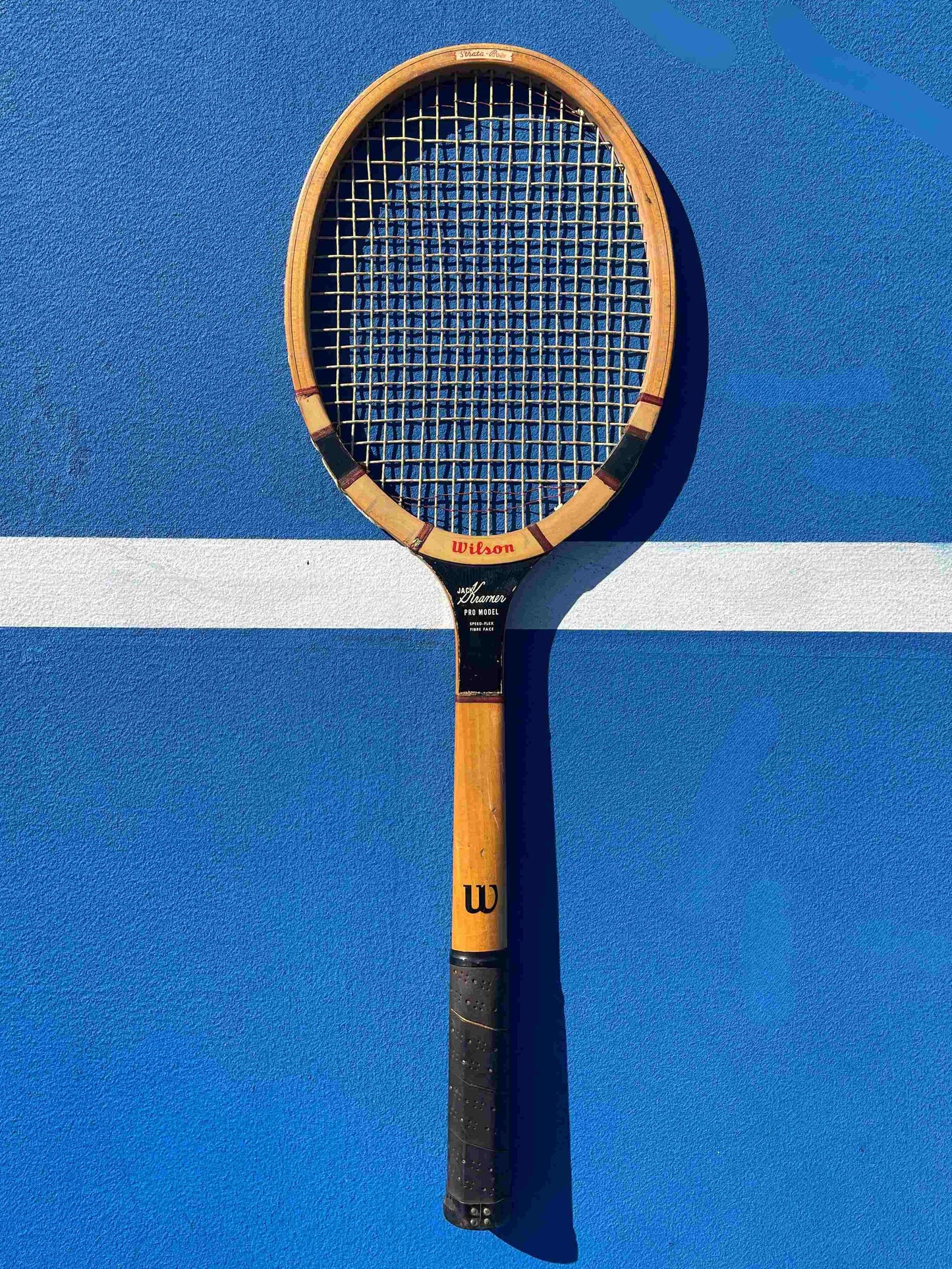 Jack Kramer Wooden Tennis Racquet on blue tennis court