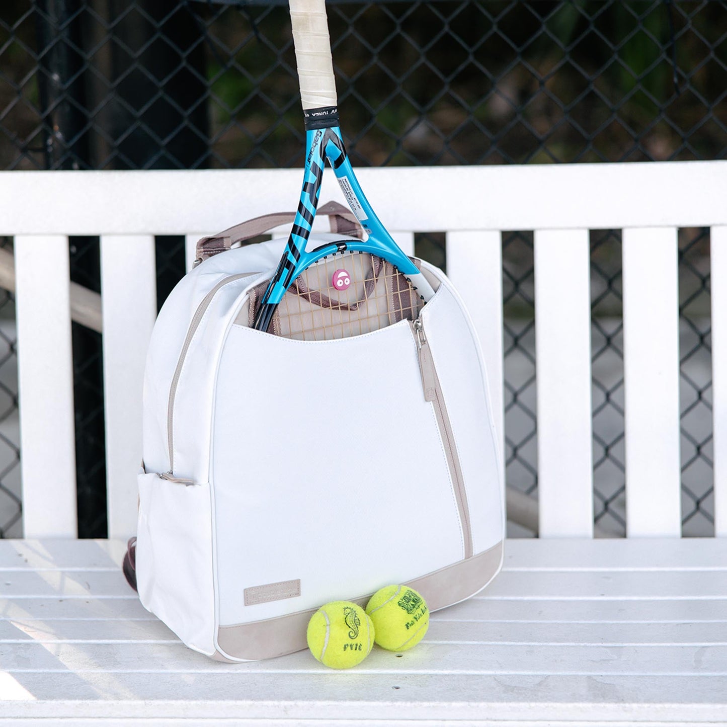 Tennis racket and balls on a white bag with a blurred background