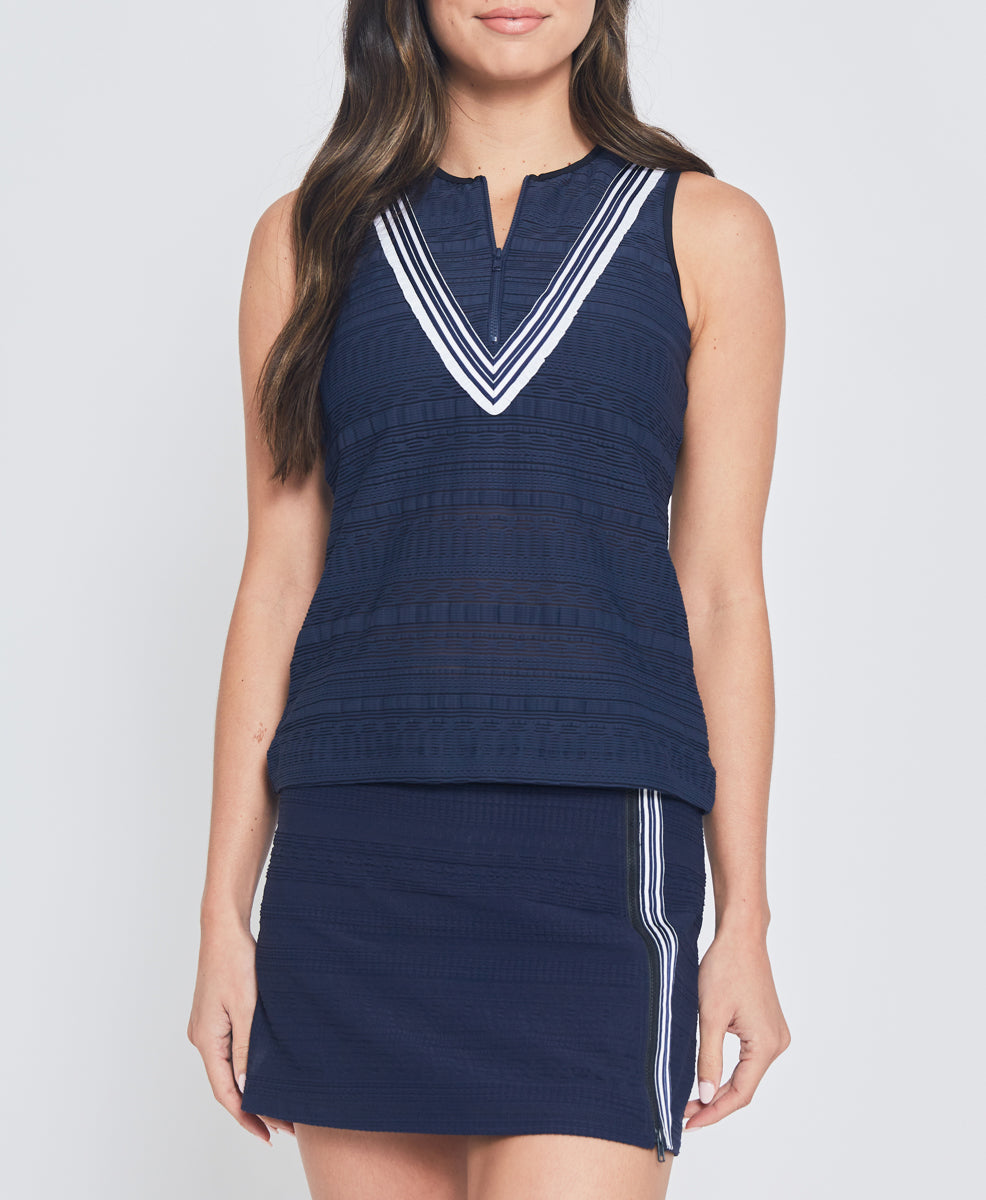 Model wearing L'Etoile Sport navy zip tank top and navy tennis skirt on TennisDuJour.com.