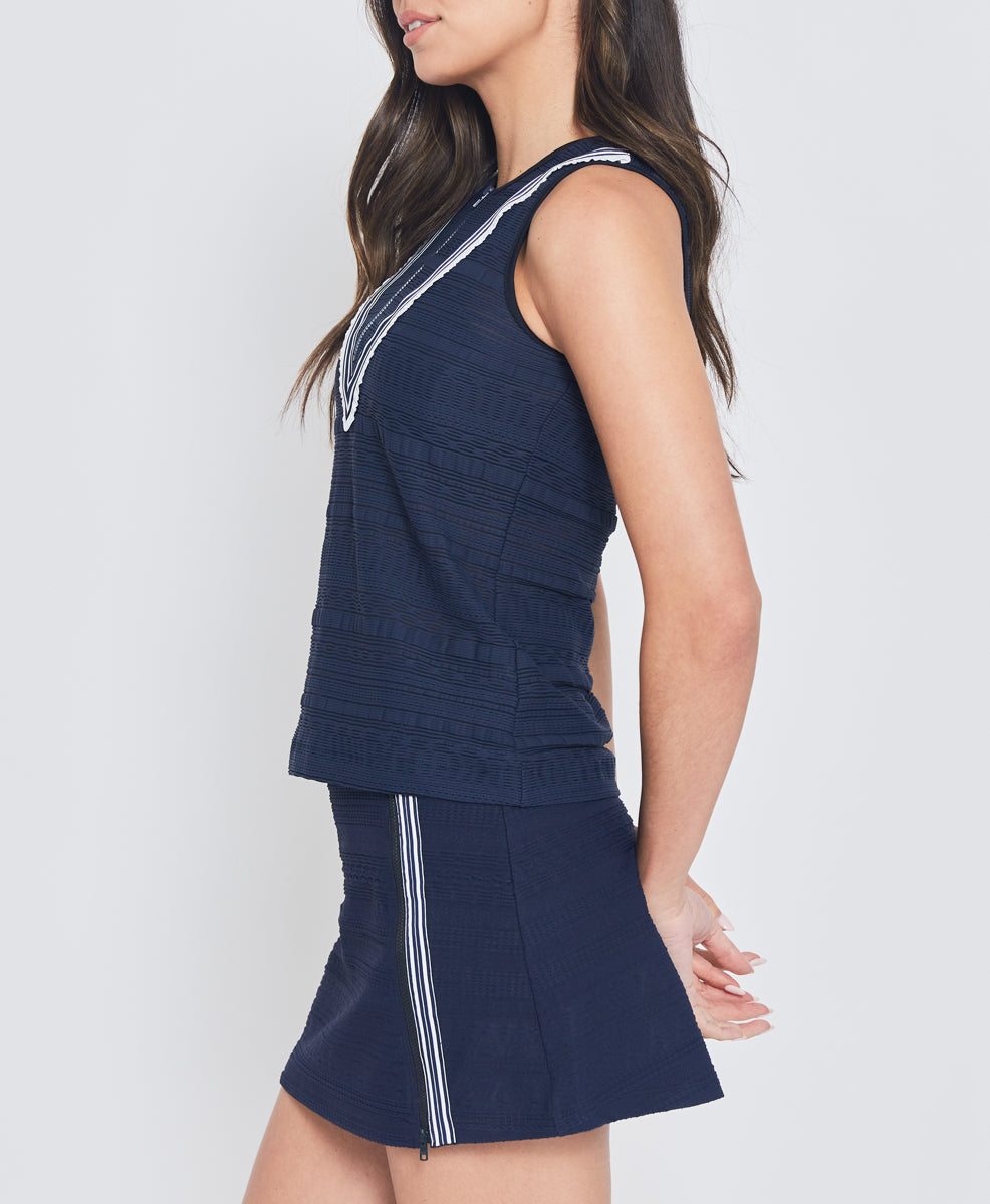 Model wearing L'Etoile Sport navy zip tank top and navy tennis skirt on TennisDuJour.com.