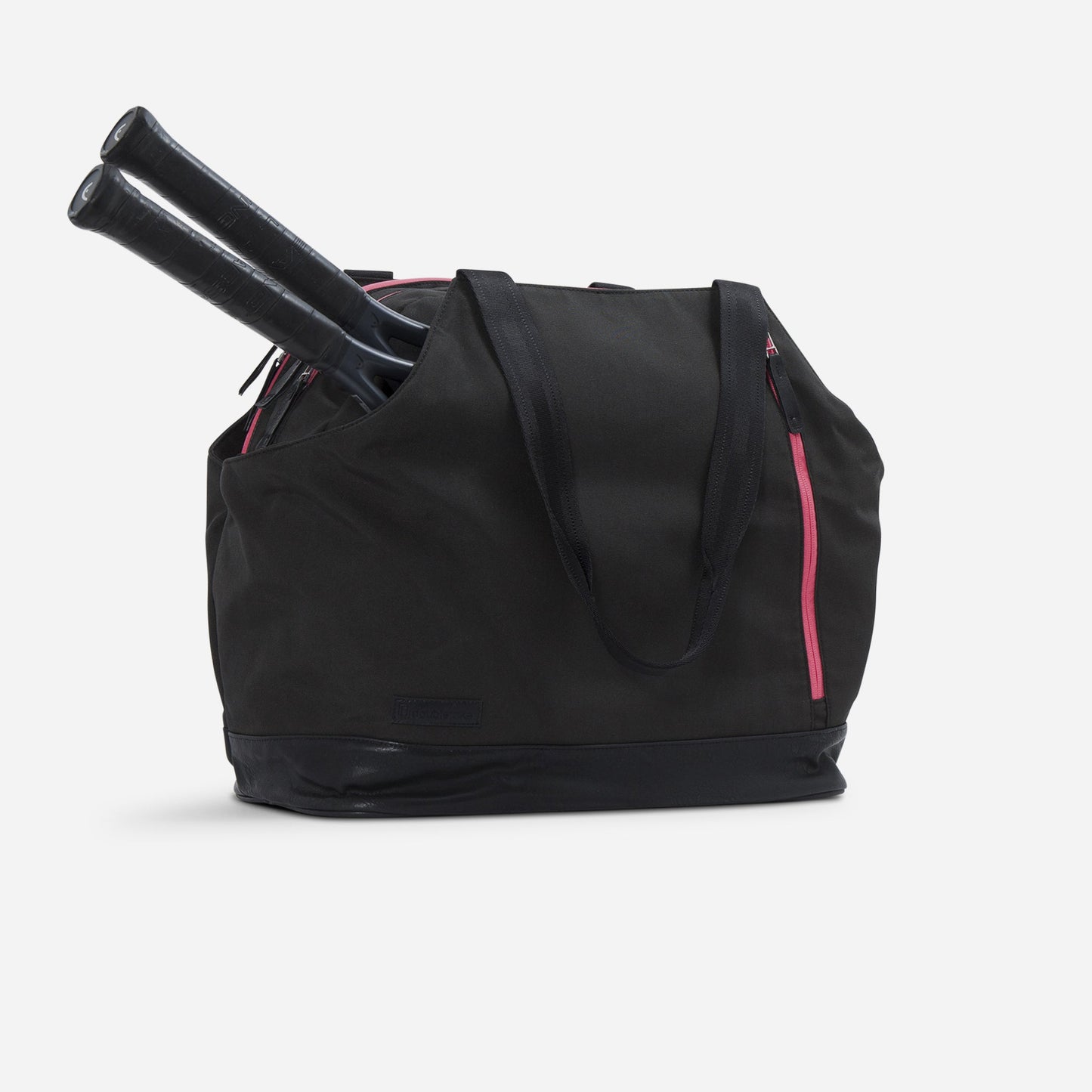 Black tennis tote bag with pink zippers holding two tennis rackets on a white background