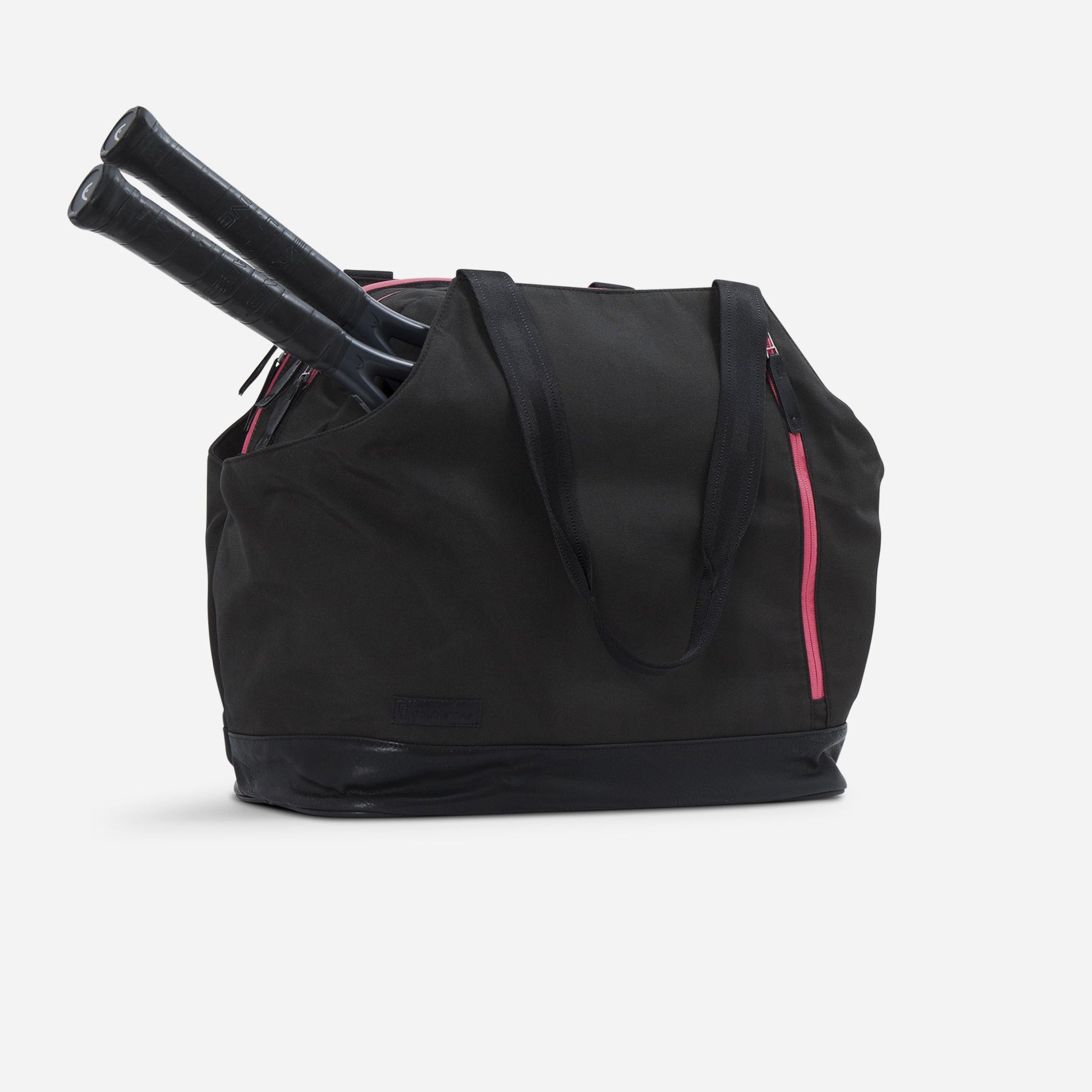 Black tennis tote bag with pink zippers holding two tennis rackets on a white background