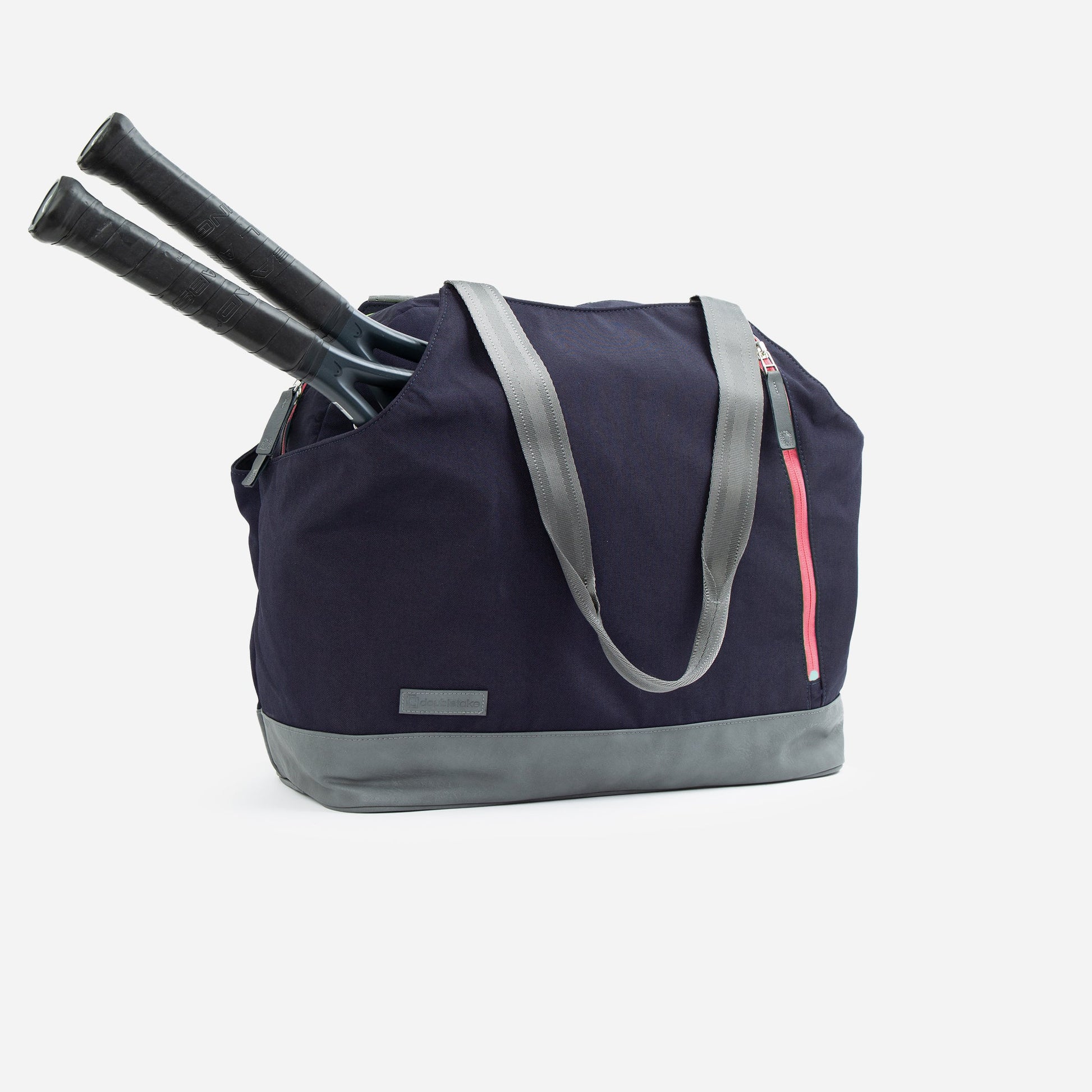 Navy blue tennis bag with gray handles and pink zipper, containing two black tennis rackets on a white background