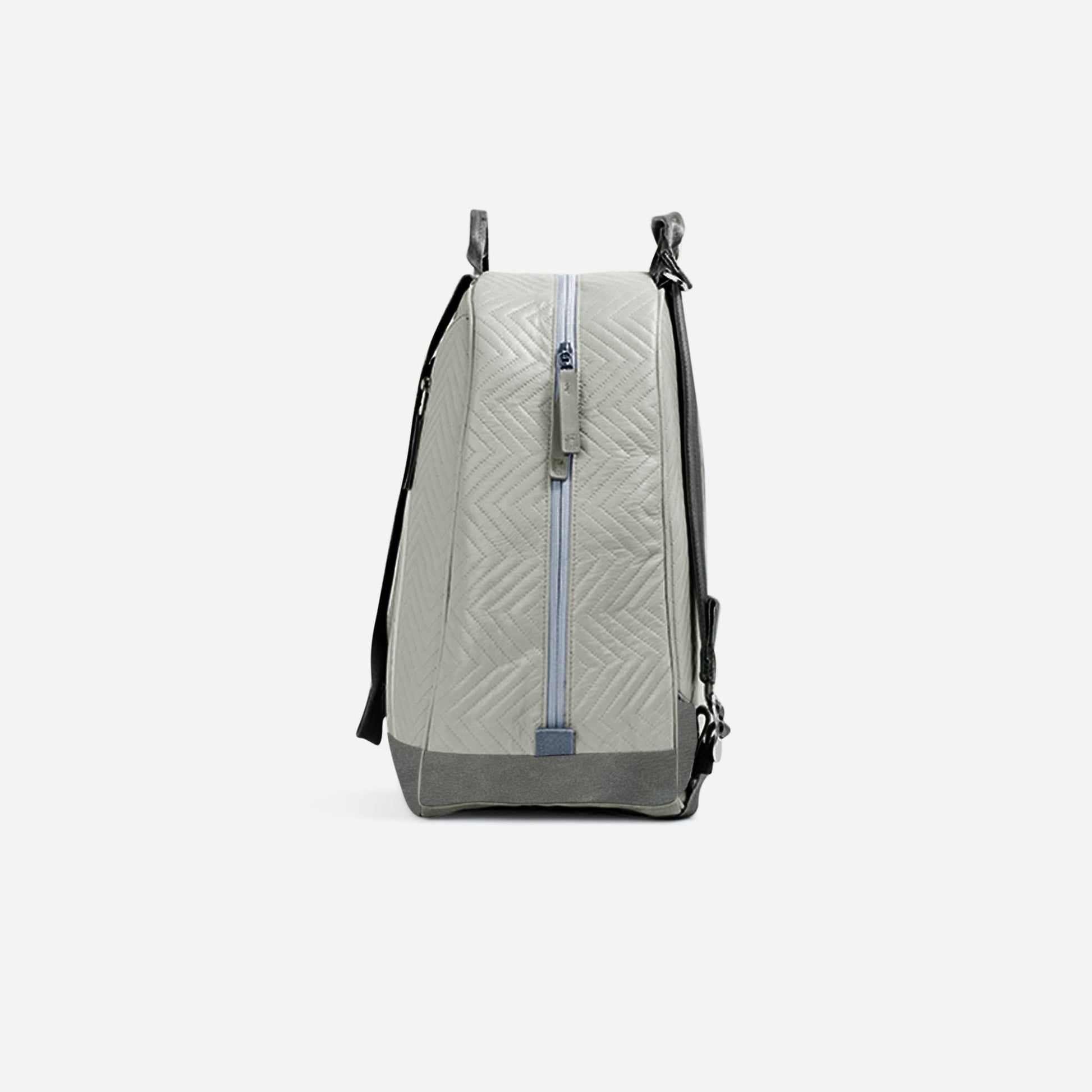 Light gray Doubletake tennis backpack with a subtle pattern on a white background