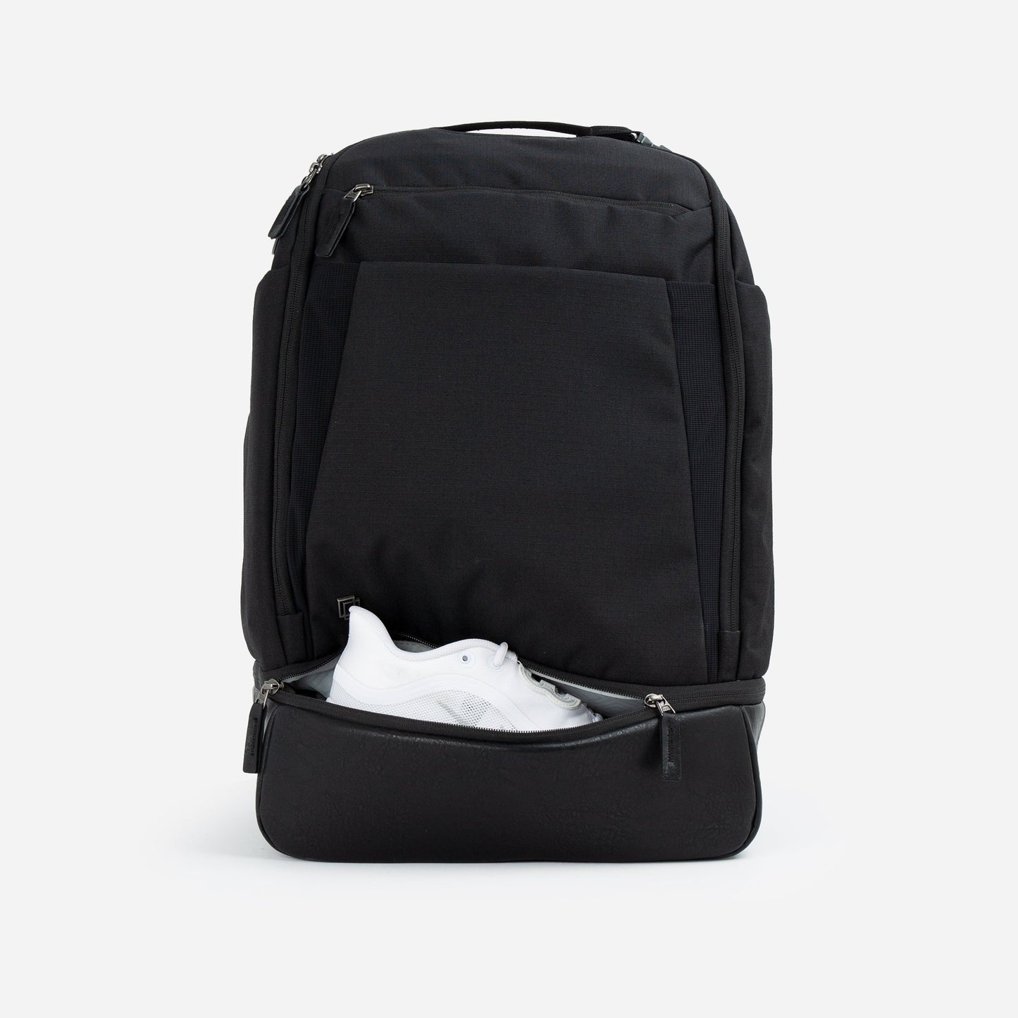 Black Doubletake tennis backpack with a white shoe inside on a light gray background