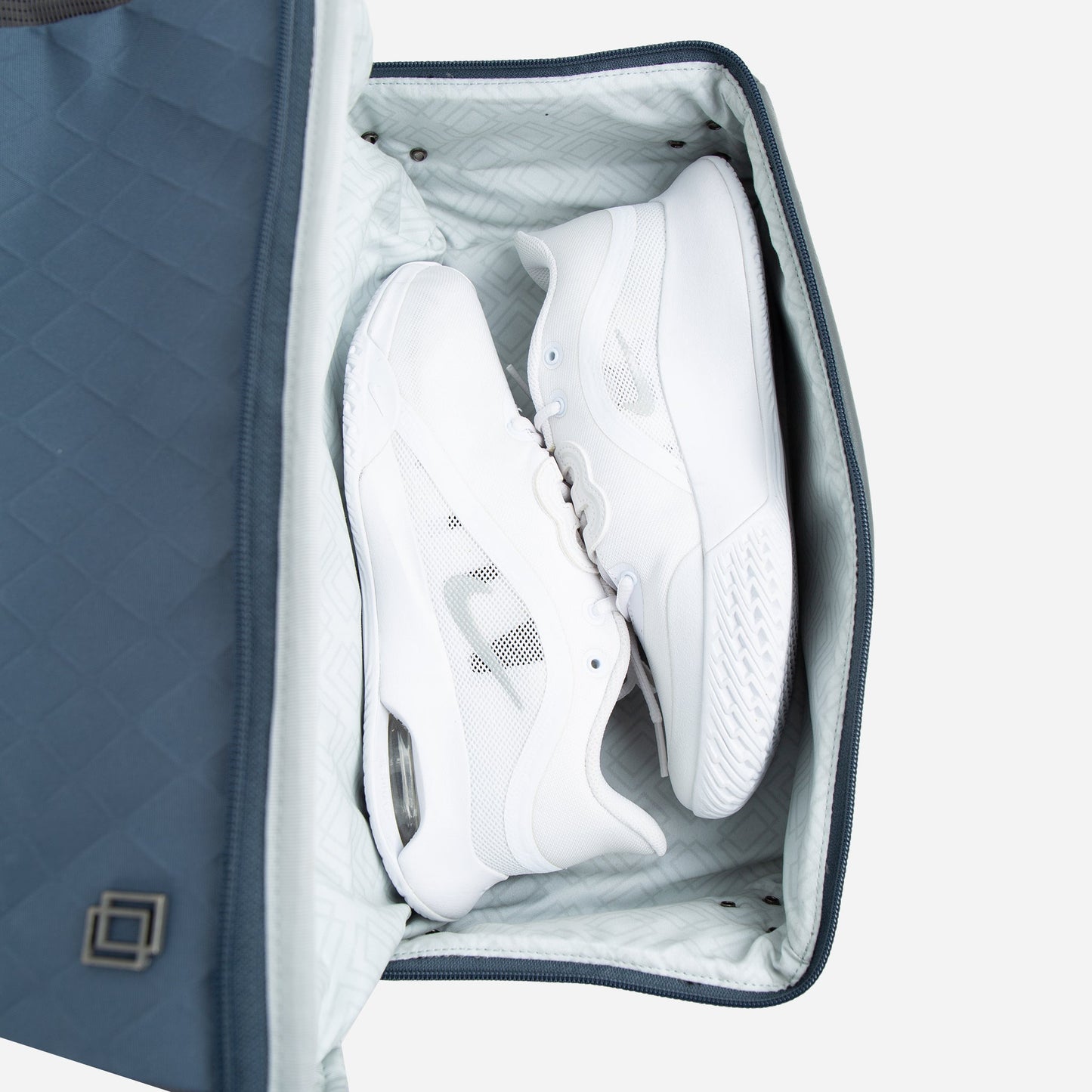 White sneakers inside a blue and gray shoebox