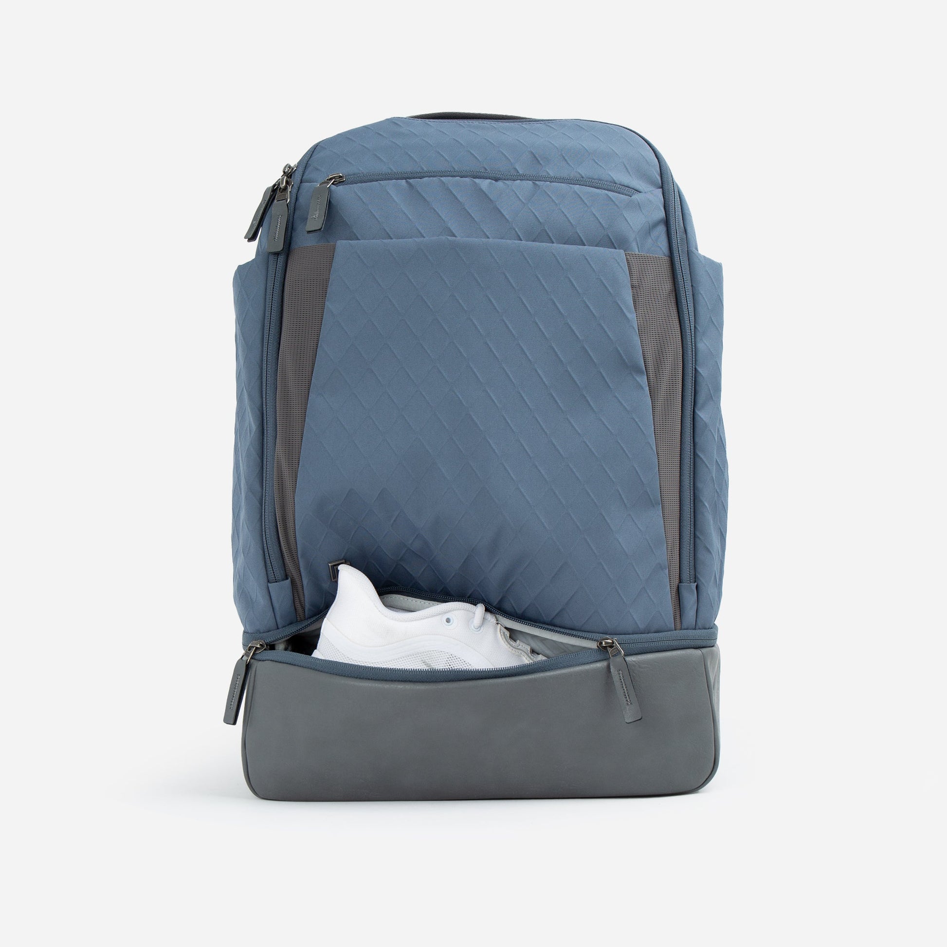 Blue and gray Doubletake tennis backpack with a shoe inside on a white background