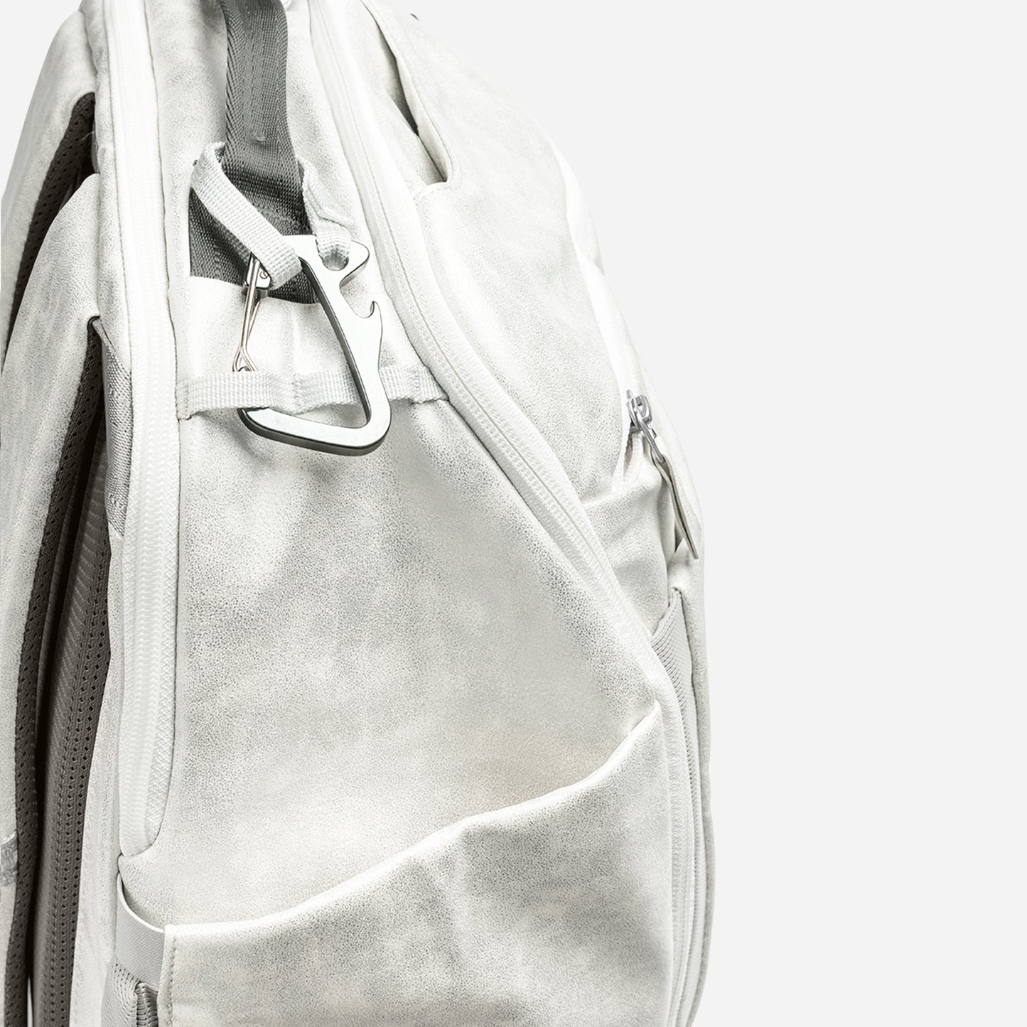 Close-up of a gray Doubletake tennis backpack with a carabiner on a white background