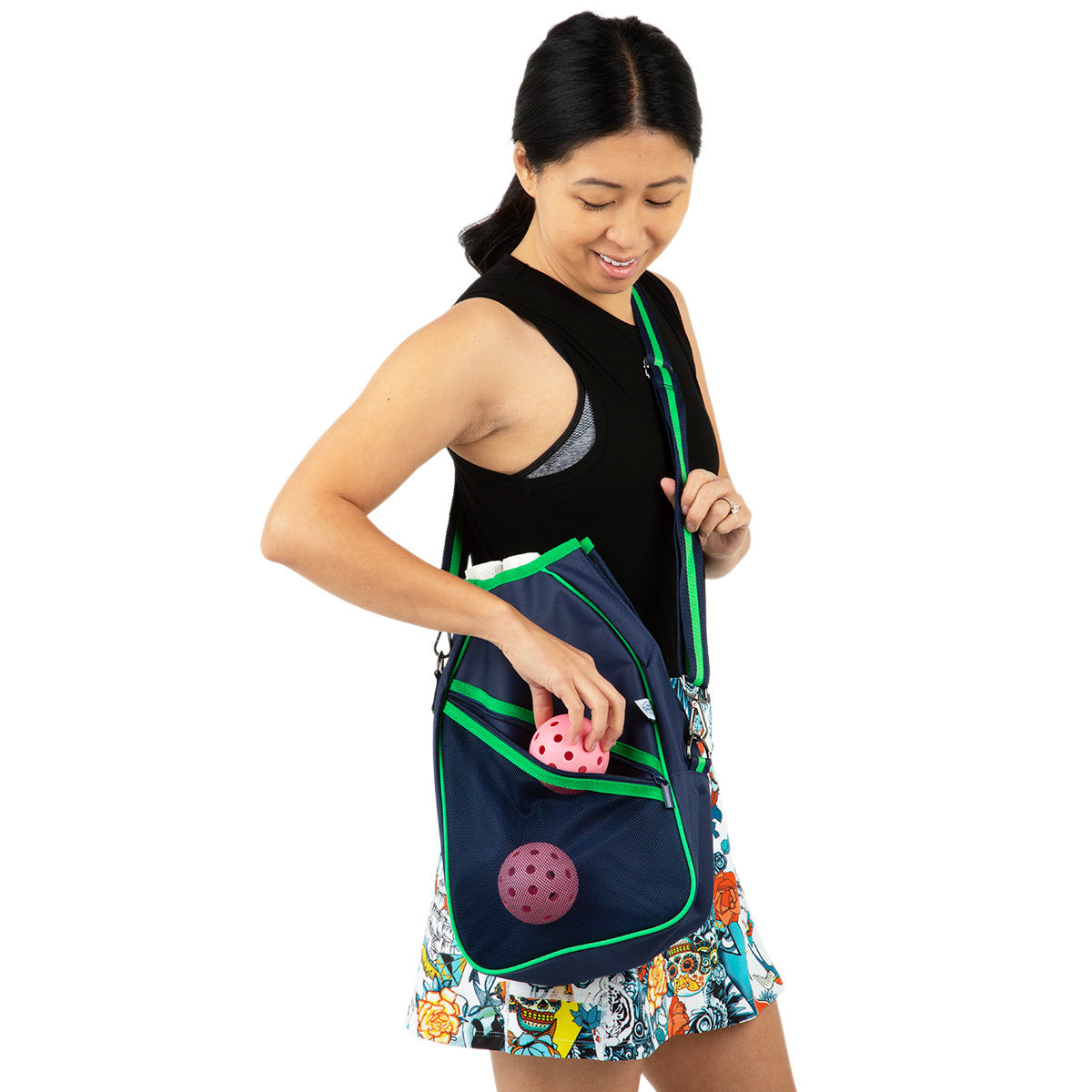Woman holding a blue  pickleball bag with pink pickleball paddles on a white background