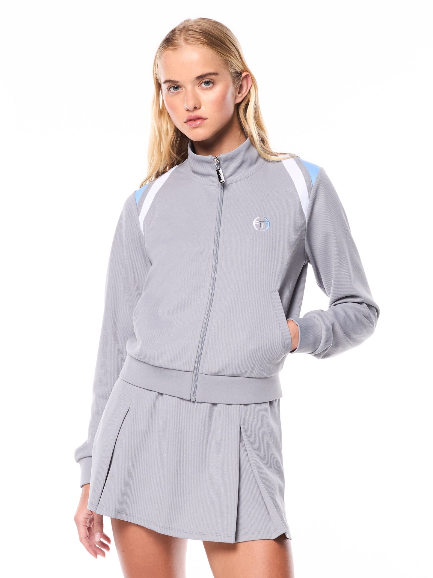 Woman wearing a gray tracksuit with a logo on a white background