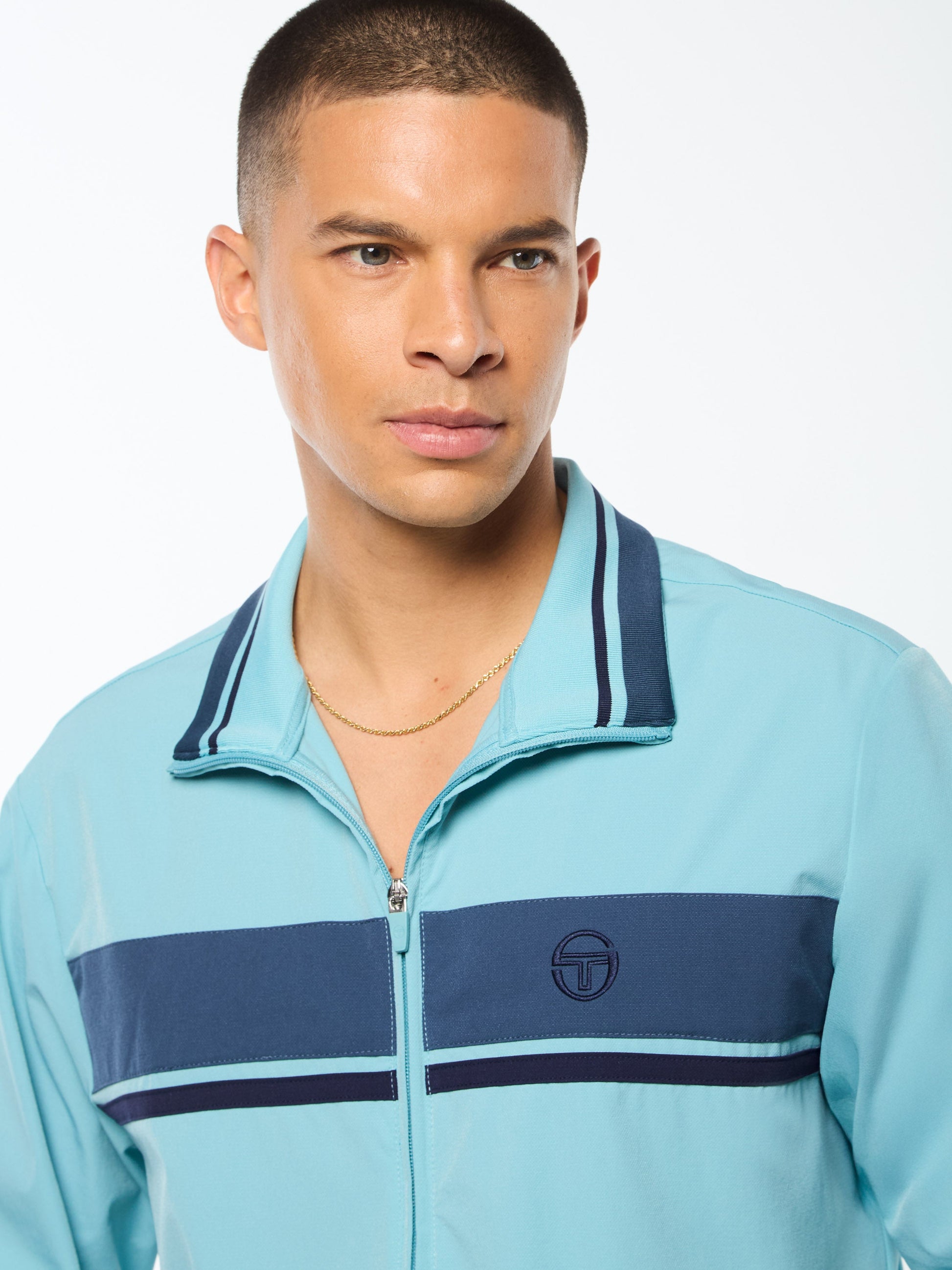 Man wearing a light blue jacket with navy accents on a white background