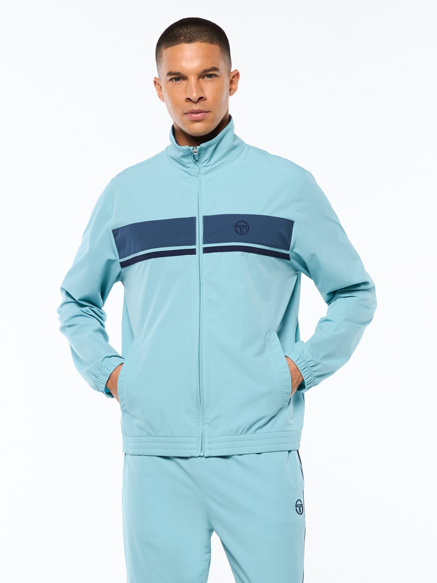 Man wearing a light blue tracksuit with a dark blue stripe on a white background