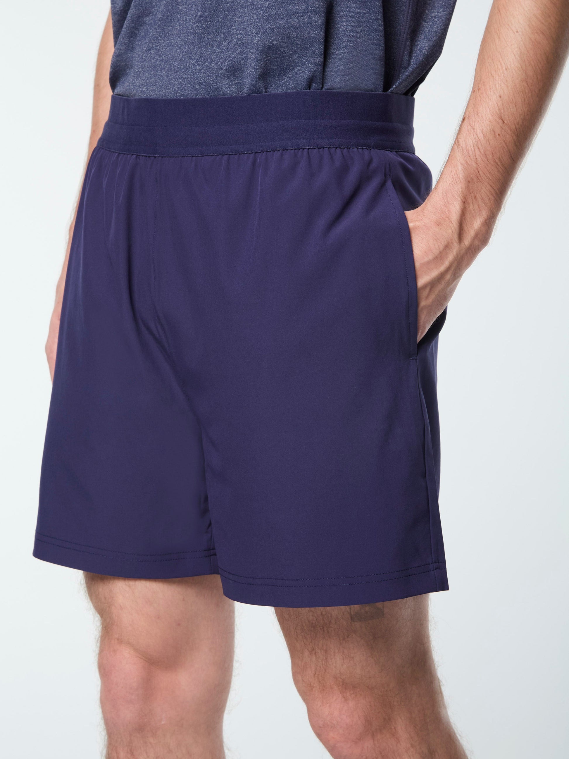 Navy blue athletic shorts worn by a person on a white background