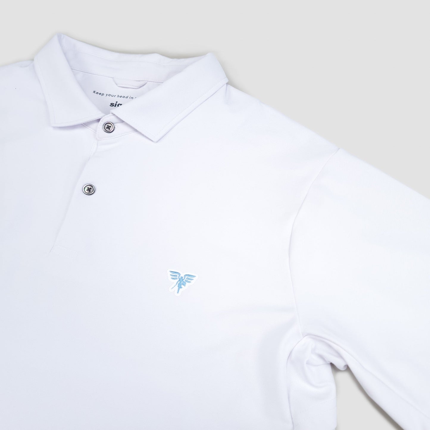 White polo shirt with a small blue logo on a light gray background