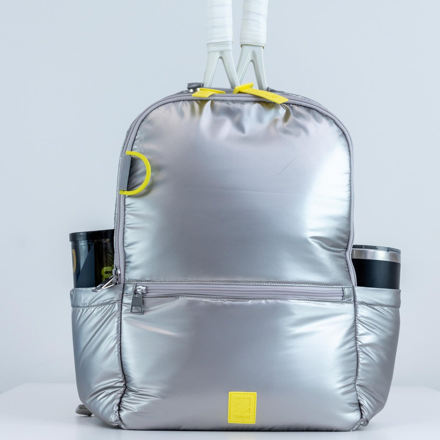 Silver backpack with yellow accents on a light gray background