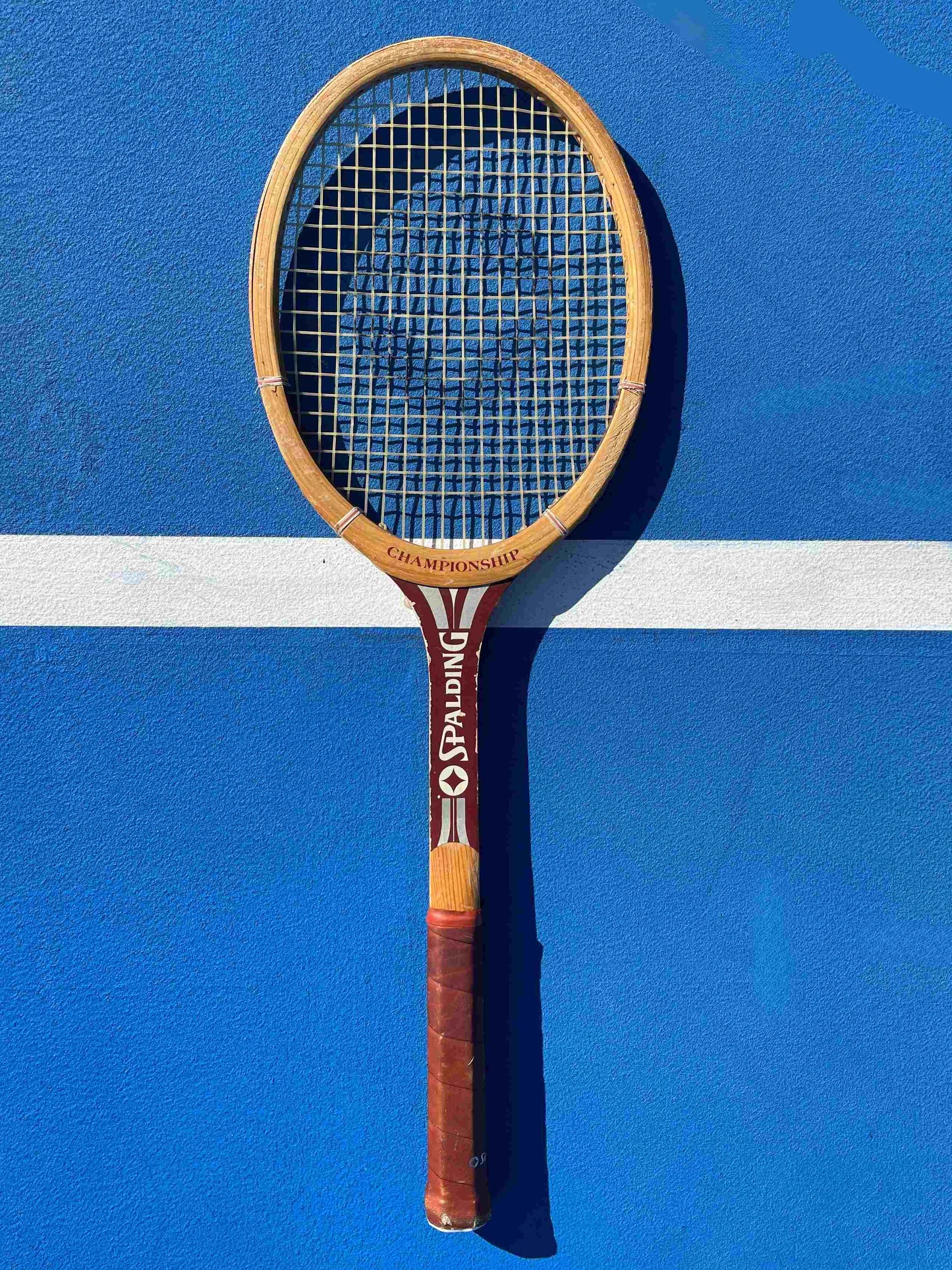 Spalding Vintage tennis racket on a blue court with white lines