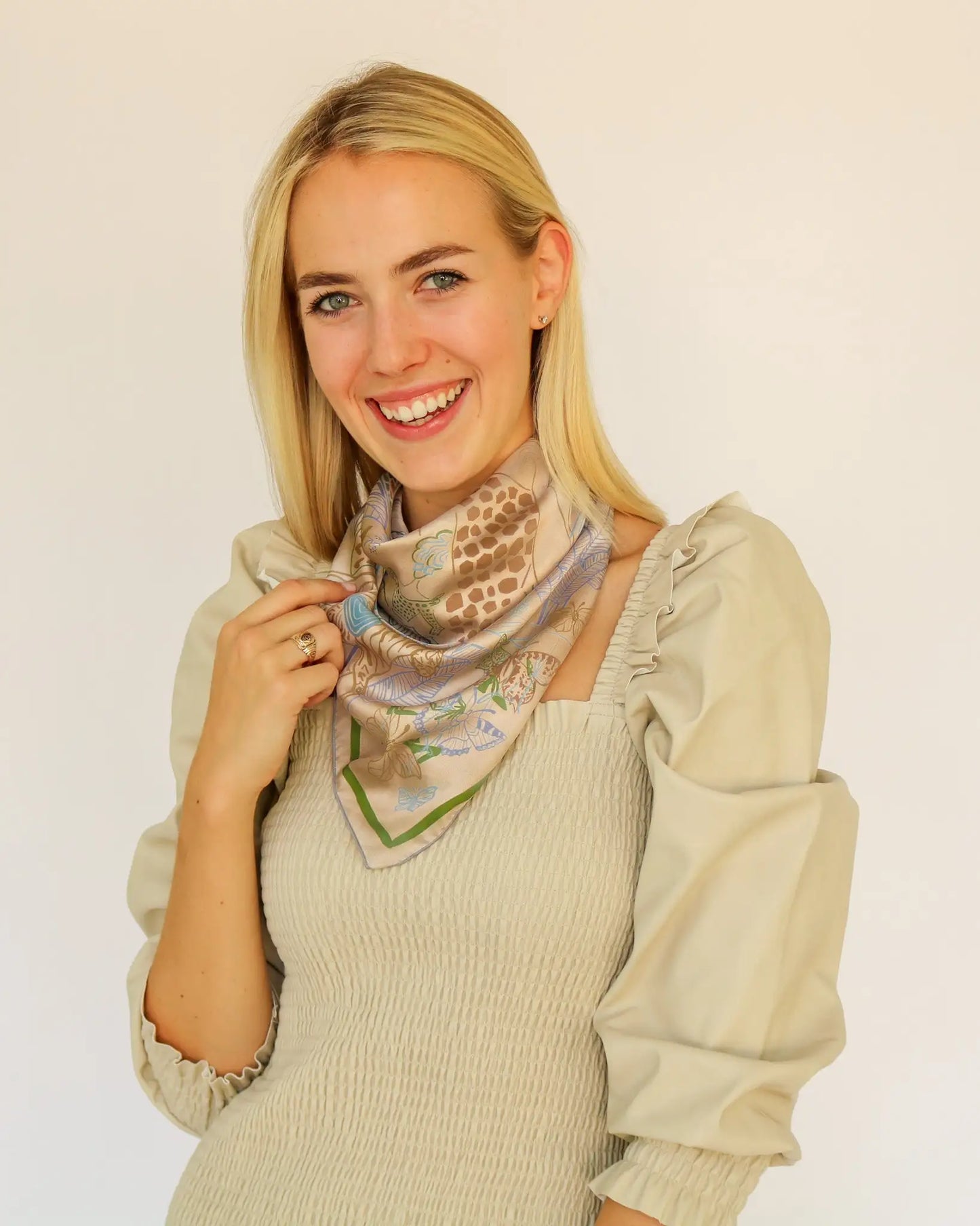 Woman wearing a patterned scarf on a plain background