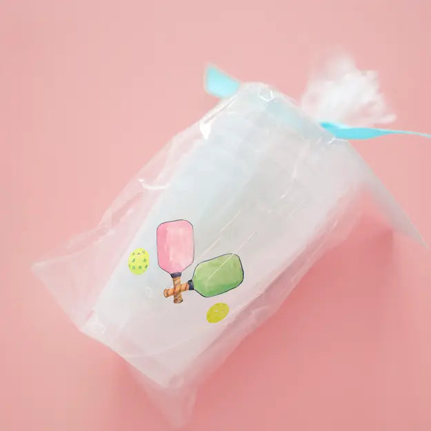 Clear drawstring bag with paddle and ball illustration on a pink background